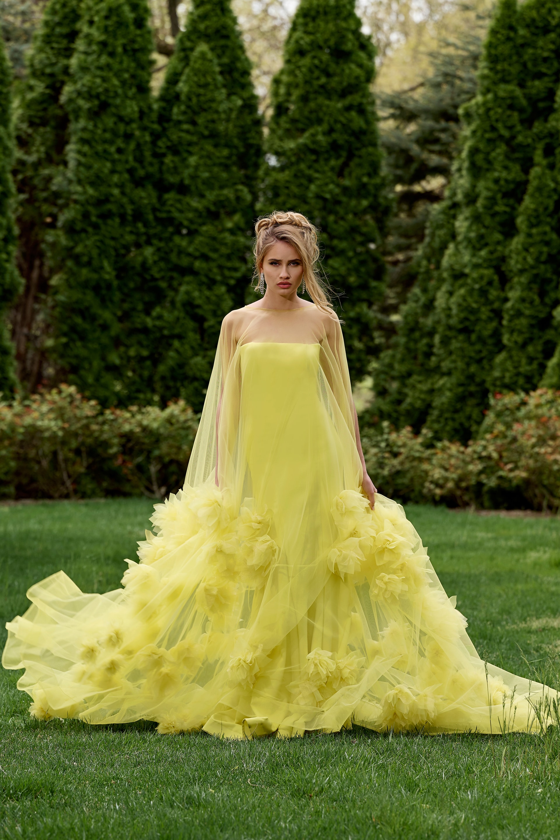 Model wearing Jovani 40092 yellow gown with strapless neckline and floral appliqués, front view