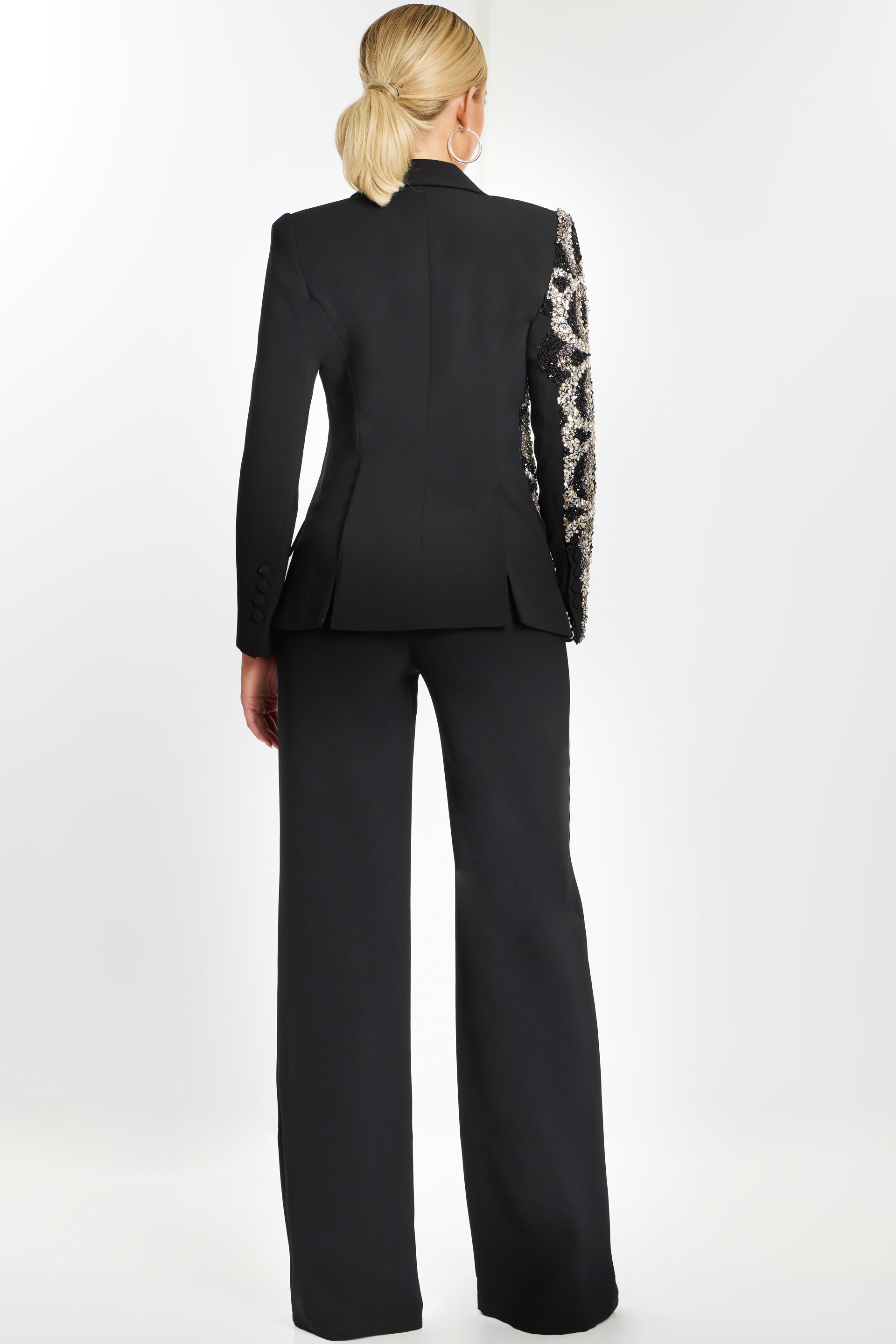 Back view of black formal pantsuit with one sequin-embellished sleeve.