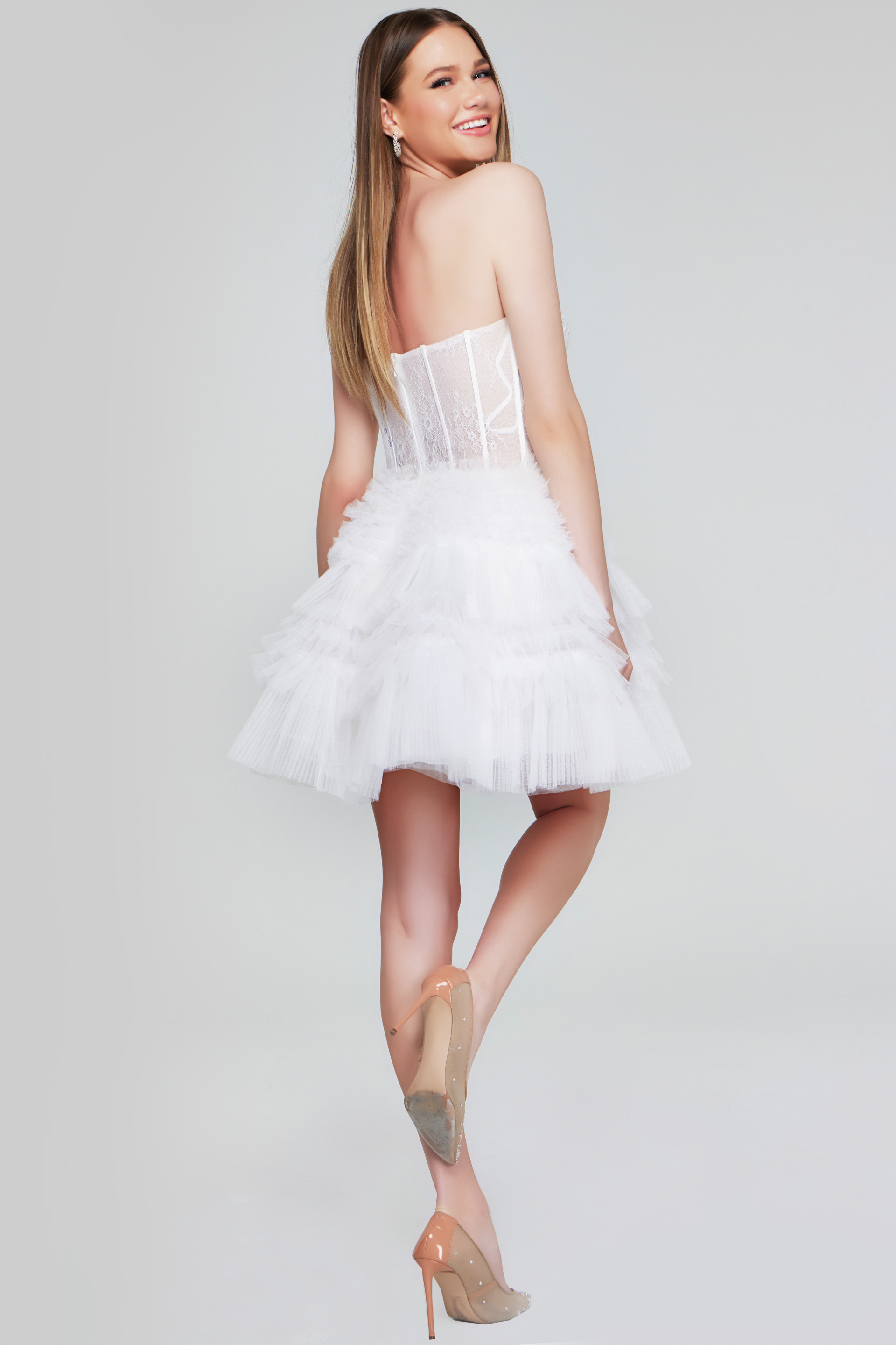 Model showing back of Jovani 40580 dress with layered tulle skirt and lace details.