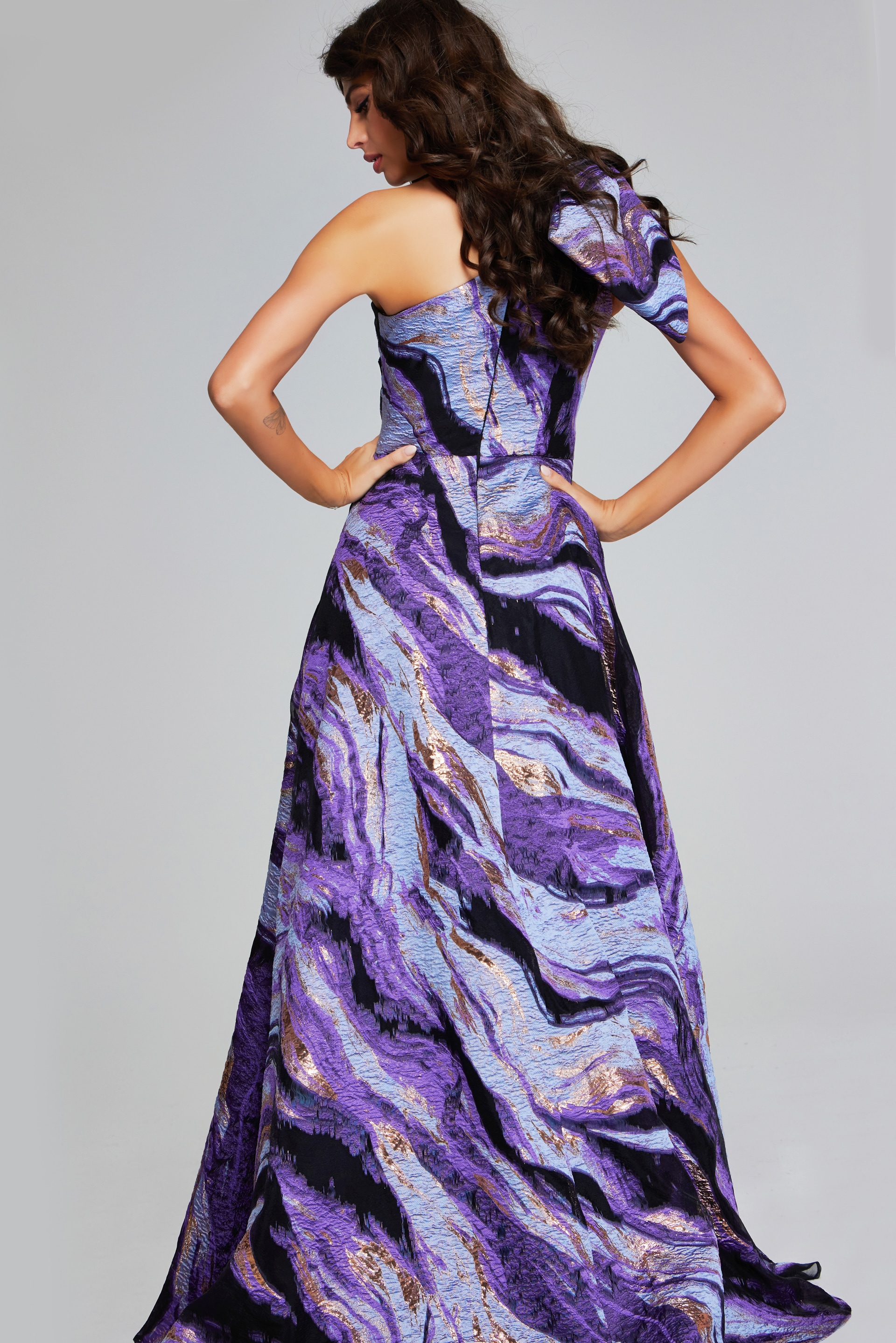 model wearing Jovani 40695 purple gown, back view highlighting flowing skirt