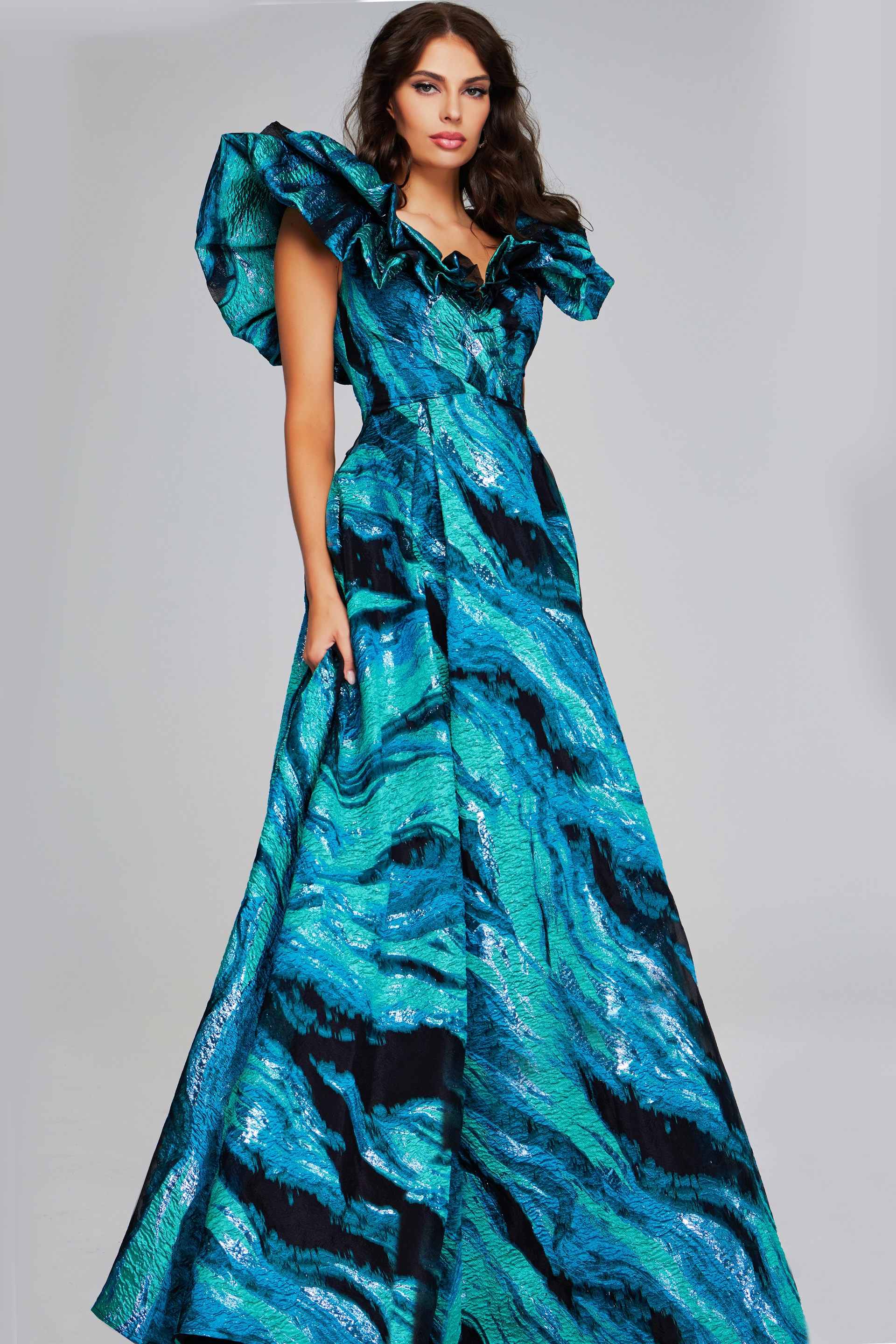 Model wearing Jovani 40696 blue gown with V-neckline and ruffled sleeves, front view.