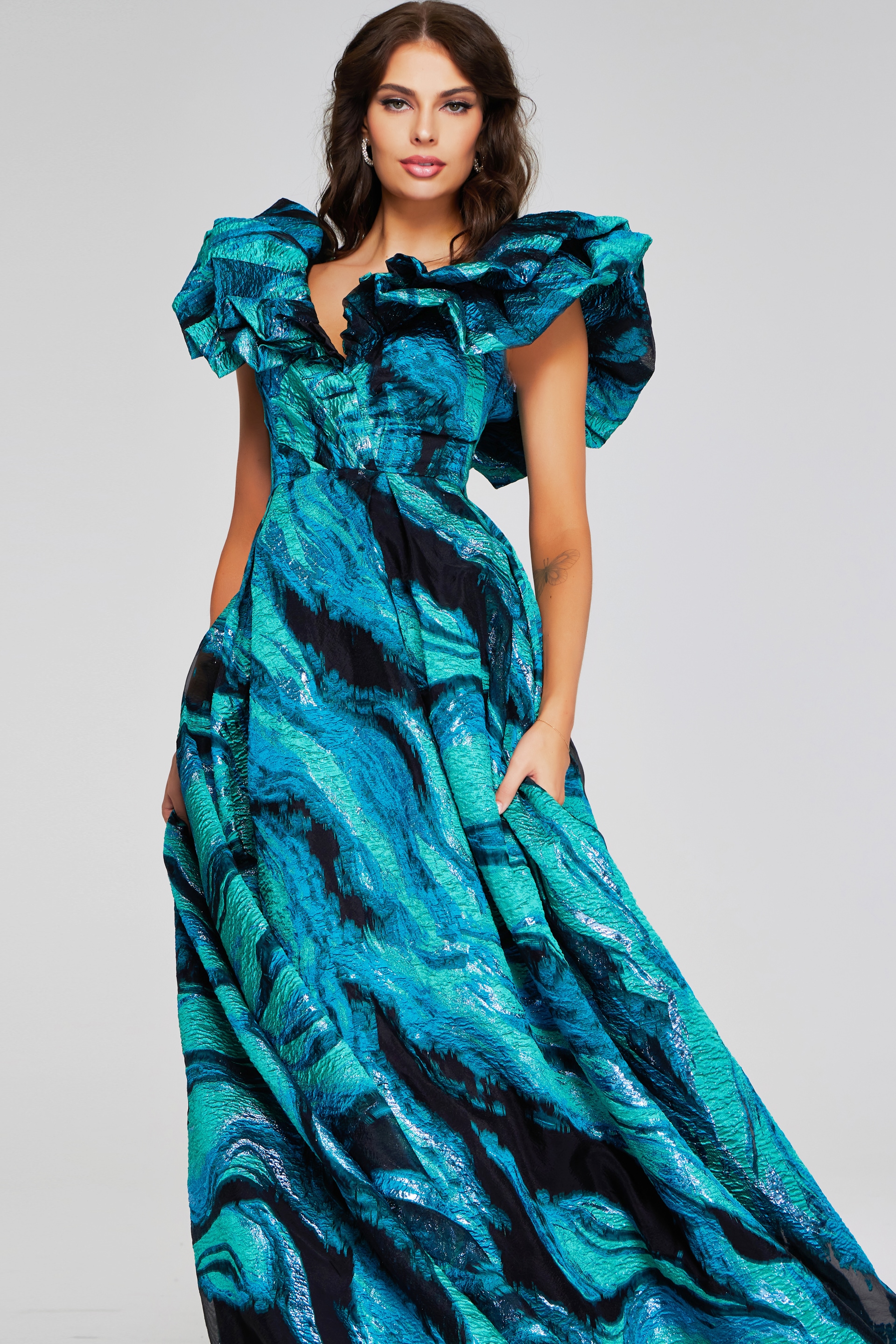 Model wearing Jovani 40696 blue gown with dramatic ruffled sleeves, front view.