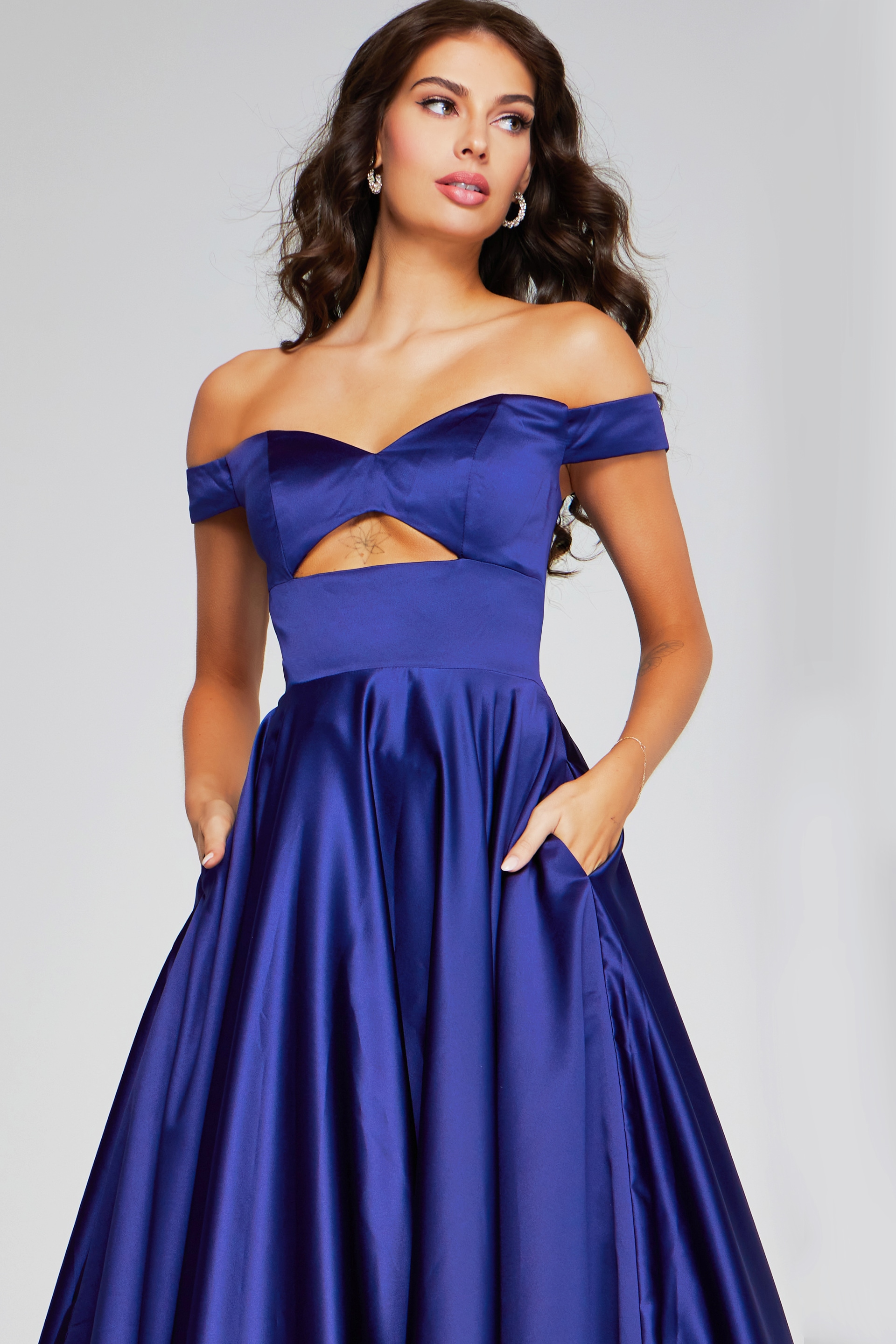 Model wearing Jovani 40787 purple off-the-shoulder dress, front view with pockets.