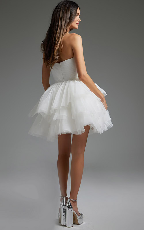 Model wearing Jovani 41054 white dress showing layered skirt, back view.