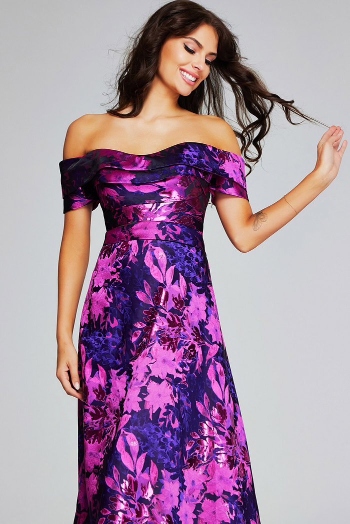 Model wearing Jovani 42506 returning gaze with a smile in fuchsia floral dress.