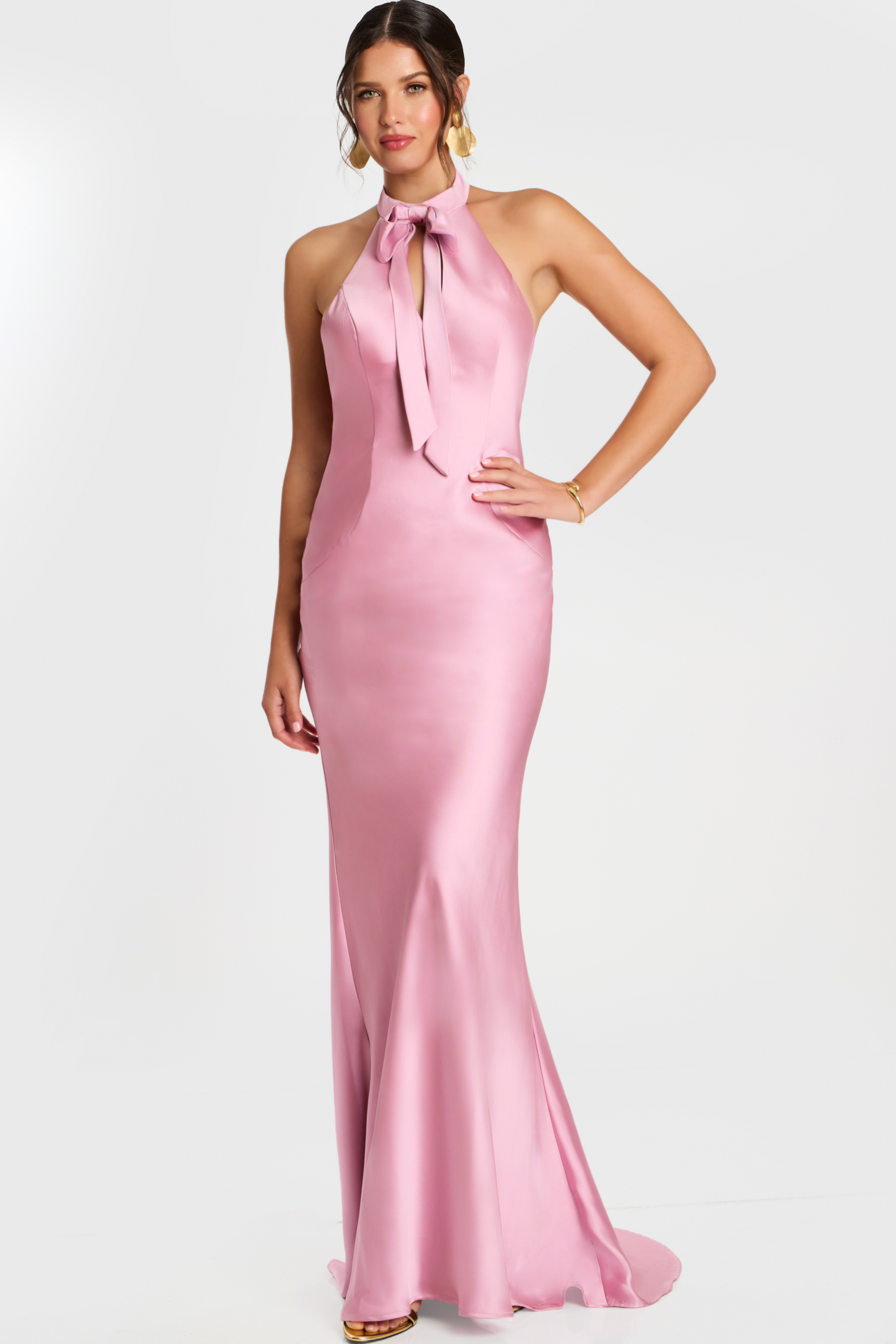 Woman wearing a mauve satin halter gown with a front bow tie and fit-and-flare silhouette.