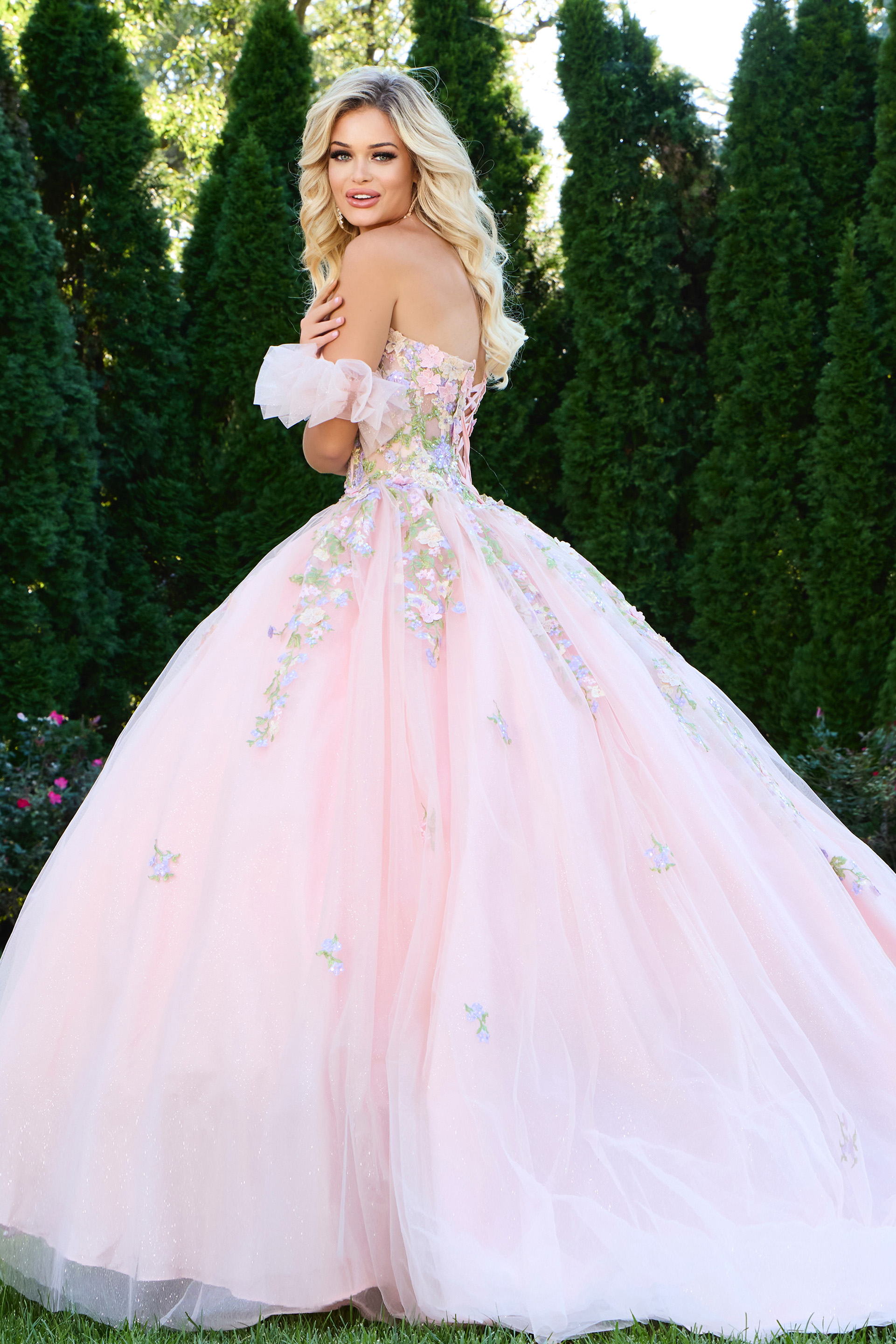 Back view of model wearing Jovani 43231 lilac ball gown showing floral appliqués.