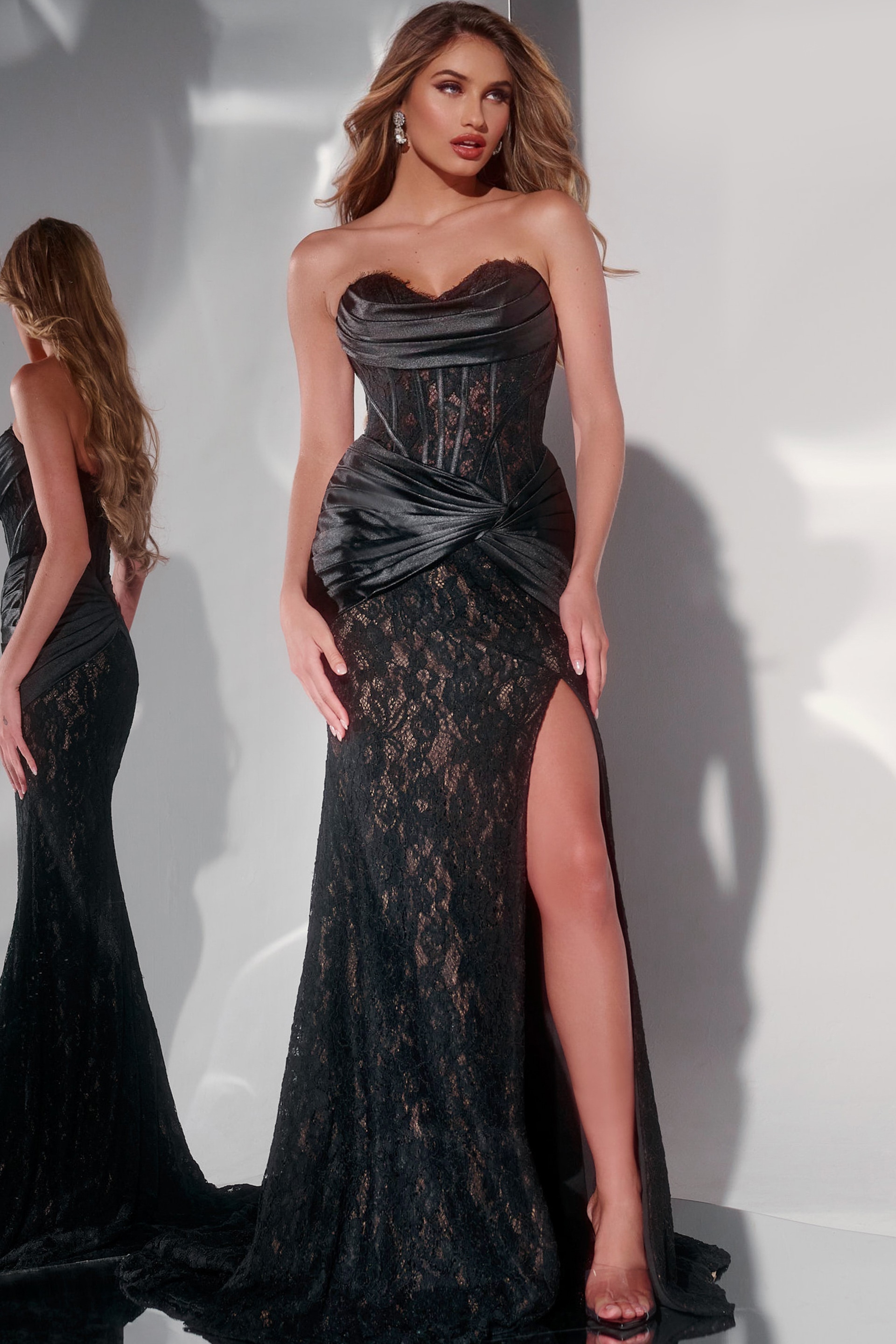 Model wearing Jovani 43859 elegant black gown with lace overlay and high slit, front view.