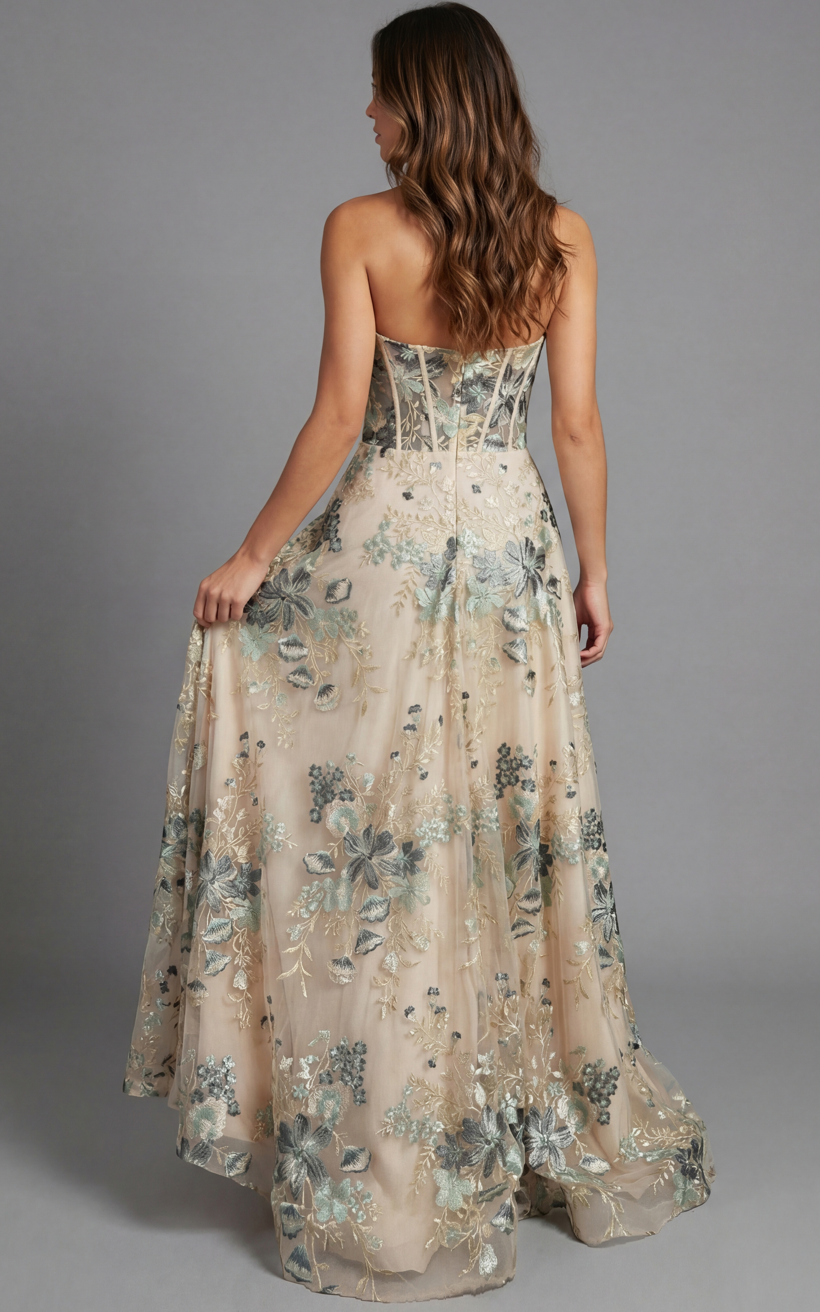 Back view of strapless evening gown with structured corset detailing and flowing skirt