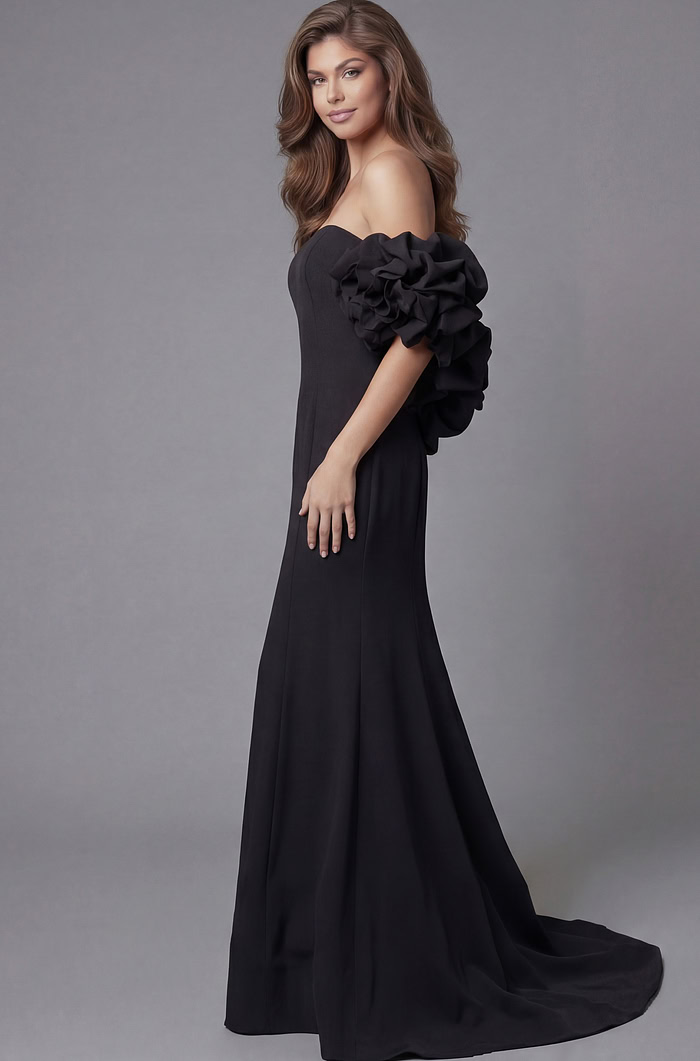 Side profile of Jovani 45653 black off-the-shoulder mermaid gown highlighting the dramatic rosette ruffle sleeve detail, clean bodice, and flowing train.