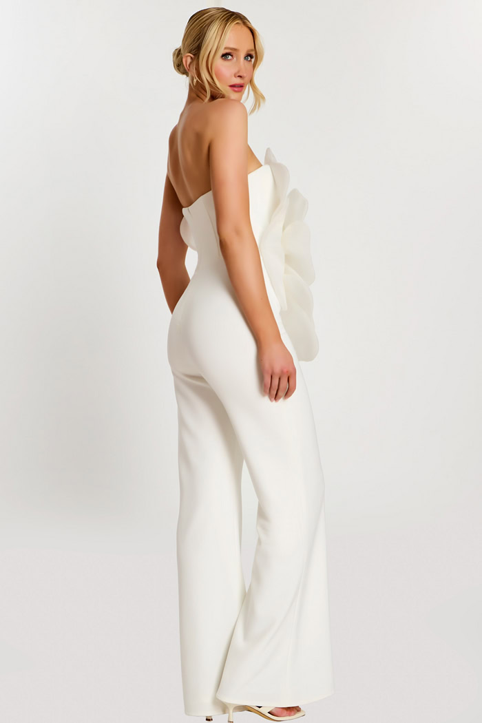 Over-the-shoulder pose showing back and side of white floral jumpsuit
