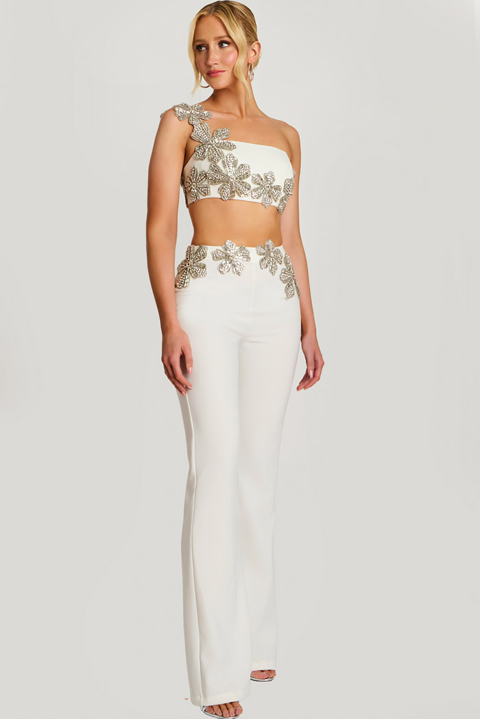Close-up of beaded floral crop top with asymmetrical strap on ivory pantsuit