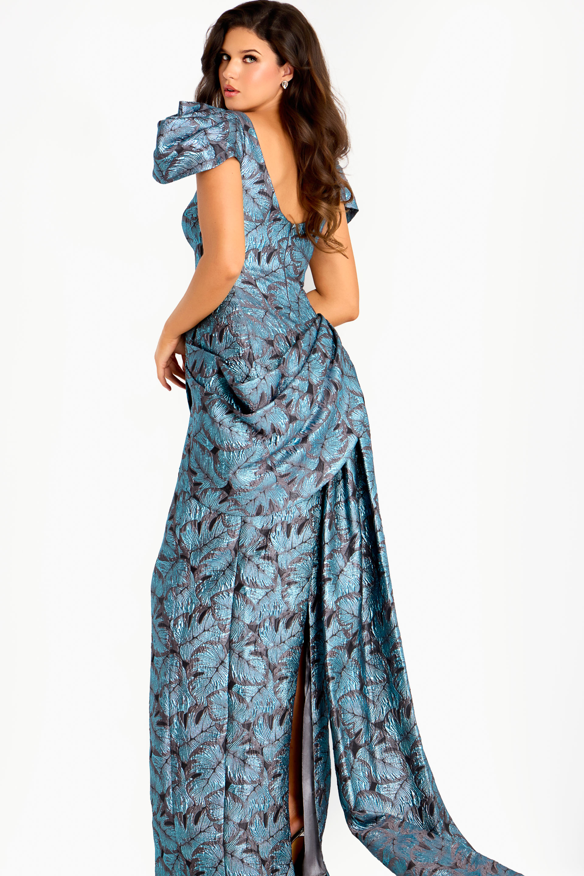 Structured metallic gown with sculpted shoulders, fitted bodice, and layered jacquard leaf pattern design.