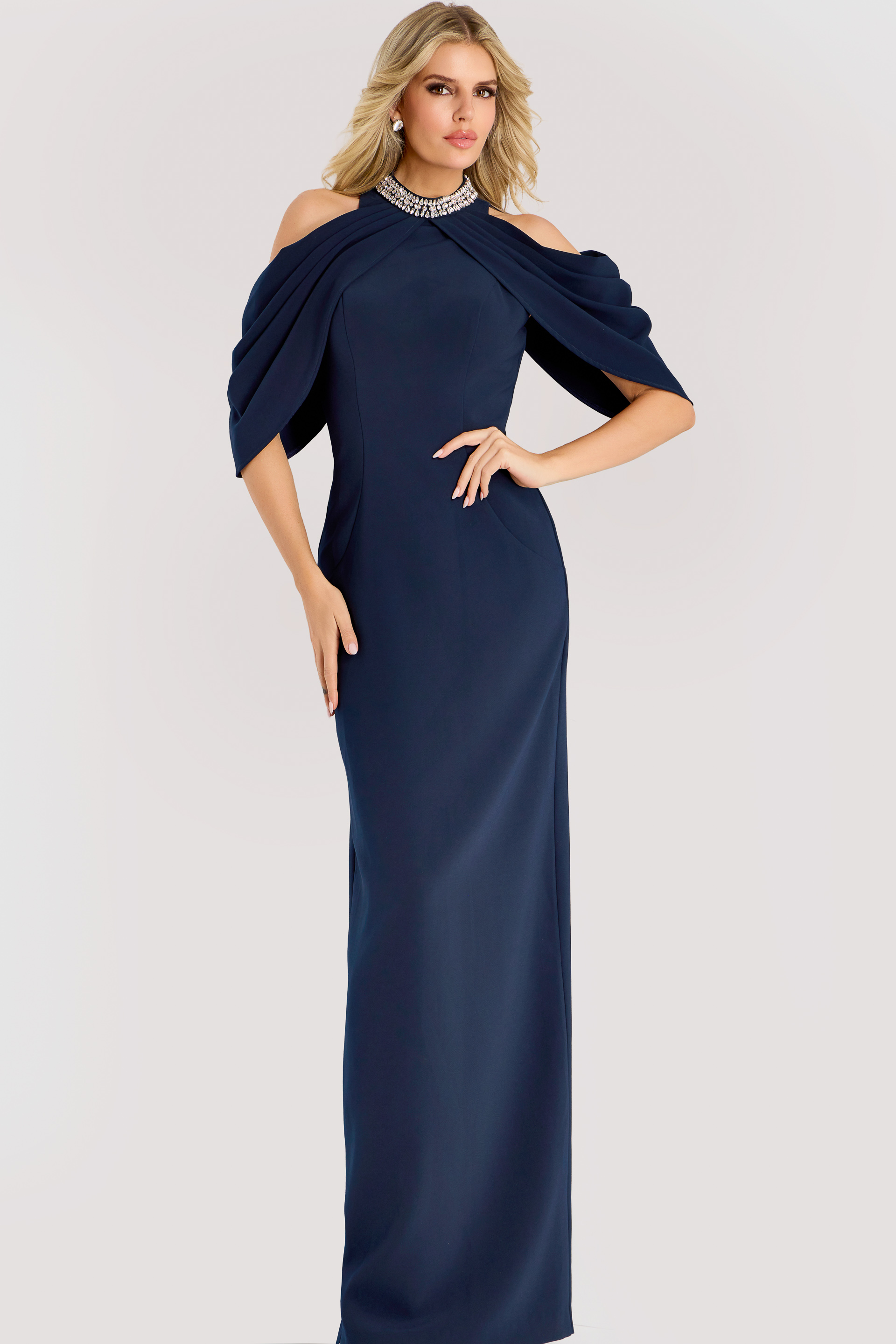 Navy cold shoulder gown with draped cape sleeves and a beaded neckline, tailored in a sleek column silhouette for a refined formal look.