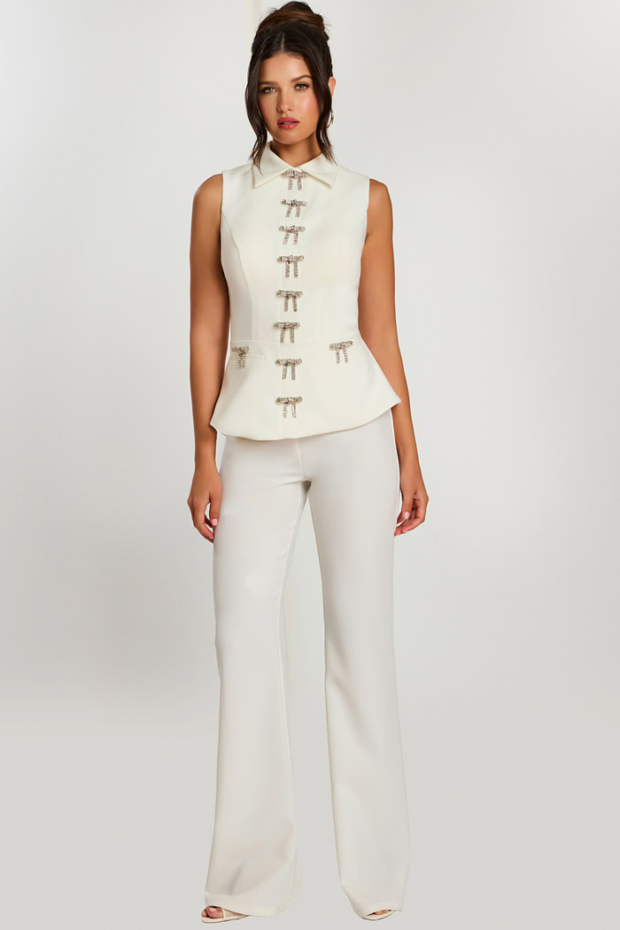 Front view of sleeveless ivory pant suit with rhinestone bow detailing