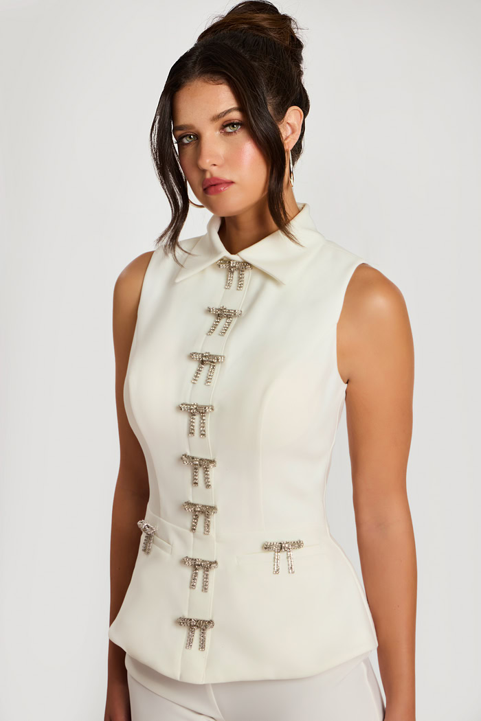 Three-quarter front view of ivory pant suit with crystal bow accents and collar