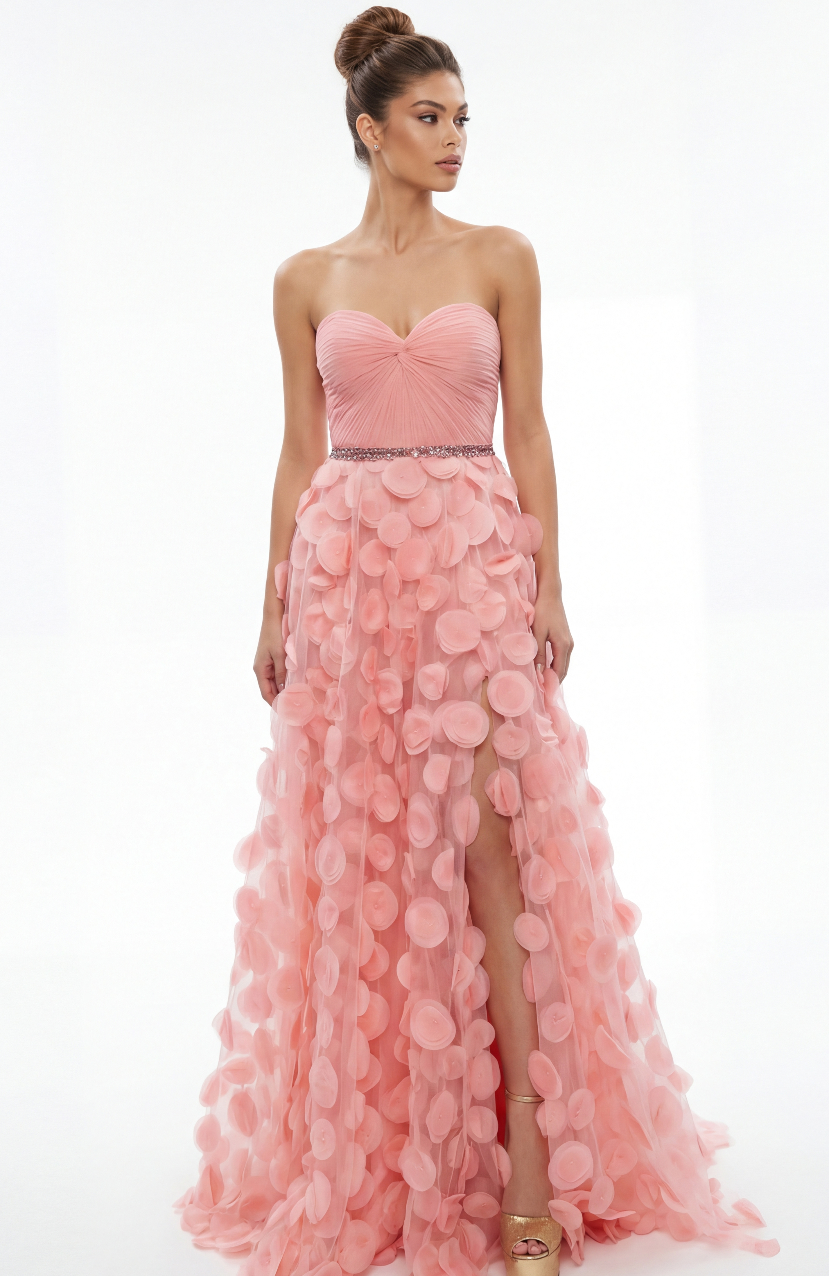 Front view of strapless gown with sweetheart neckline, gathered bodice, and textured appliqué skirt with front slit