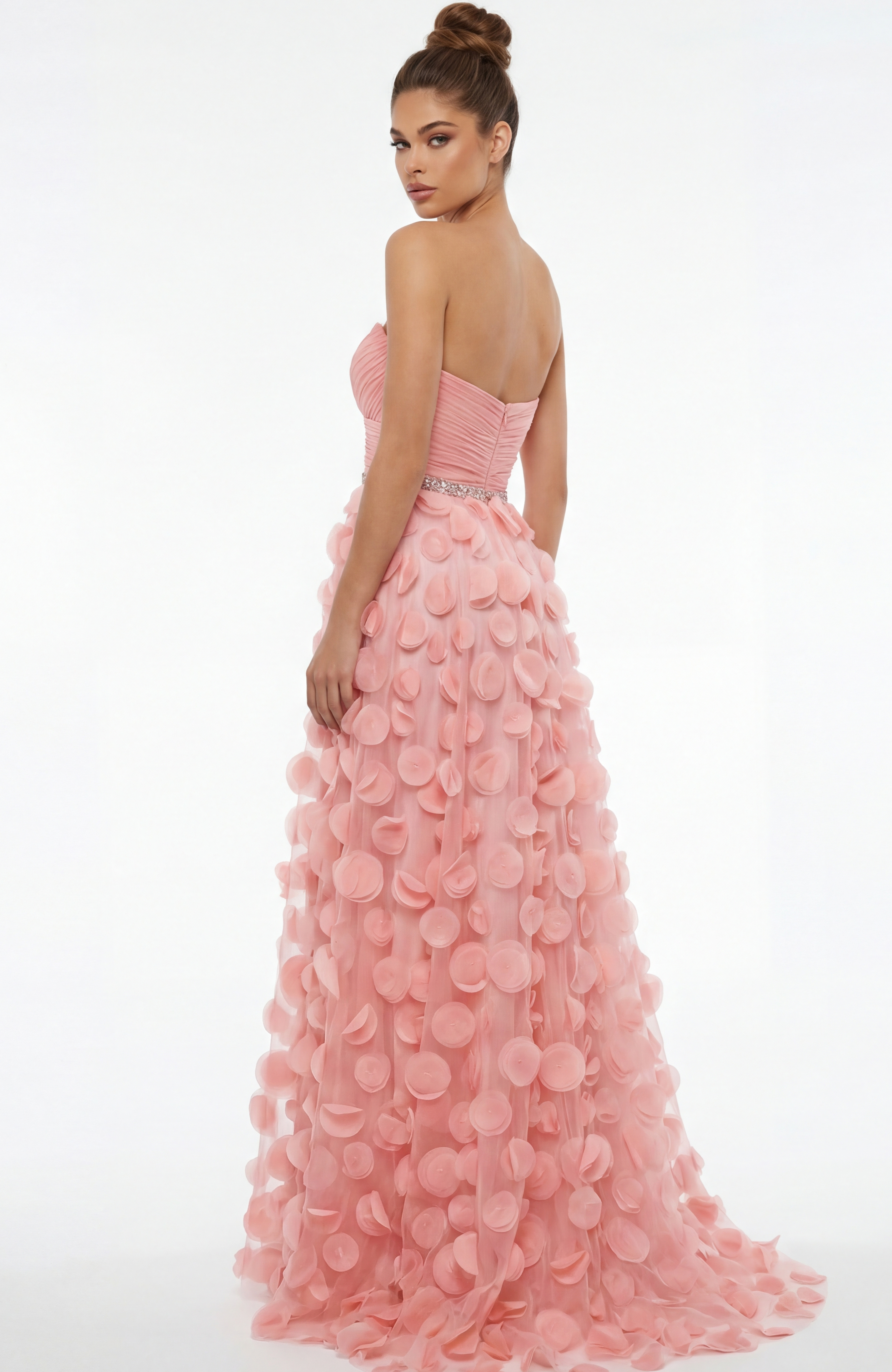 Back view of strapless gown with ruched bodice, beaded waist, and flowing skirt covered in soft circular appliqués