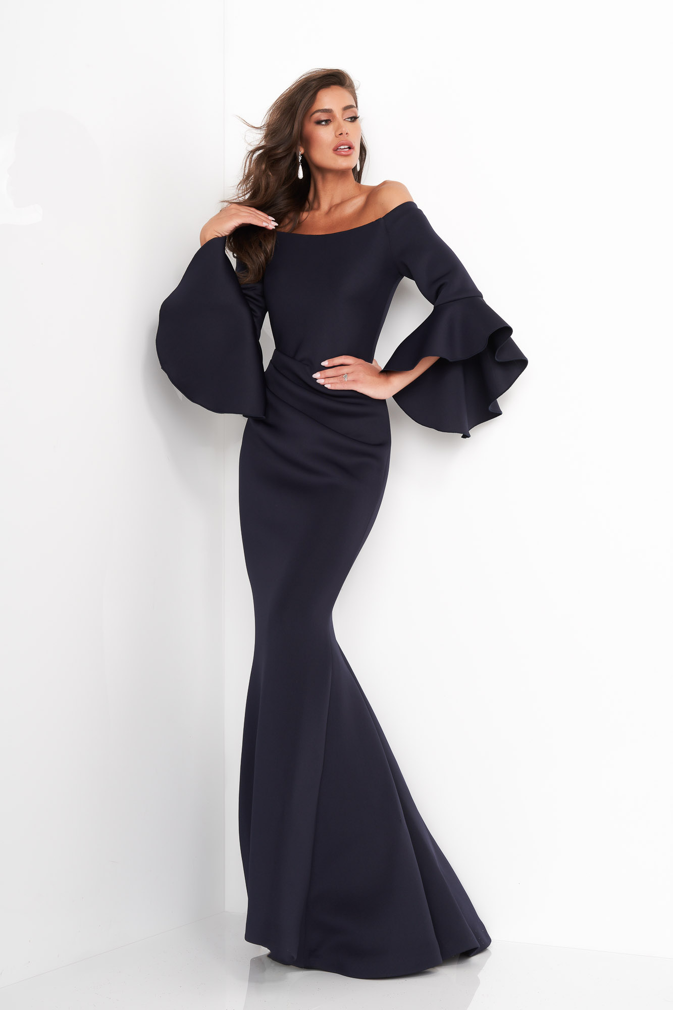 Model showcasing front of Jovani 59993 Navy mermaid gown with bell sleeves.