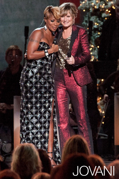 Model wearing Jovani 79121 black floor-length gown with shimmering texture.