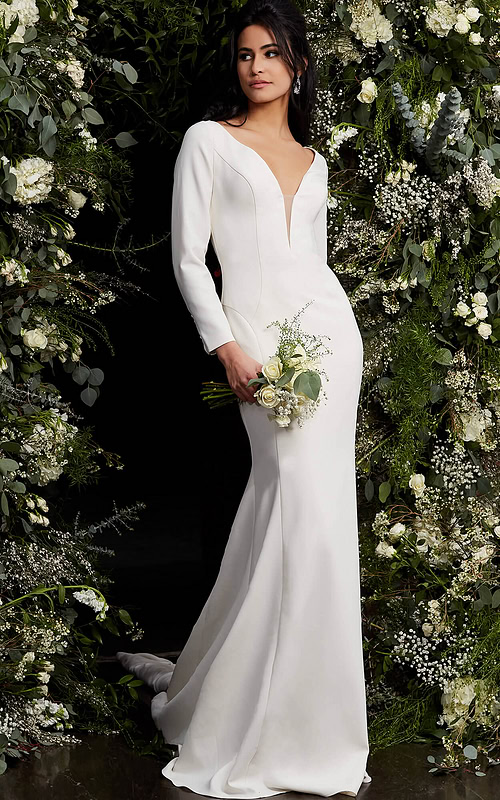 Model wearing Jovani JB06911 ivory gown featuring plunging neckline and long sleeves.