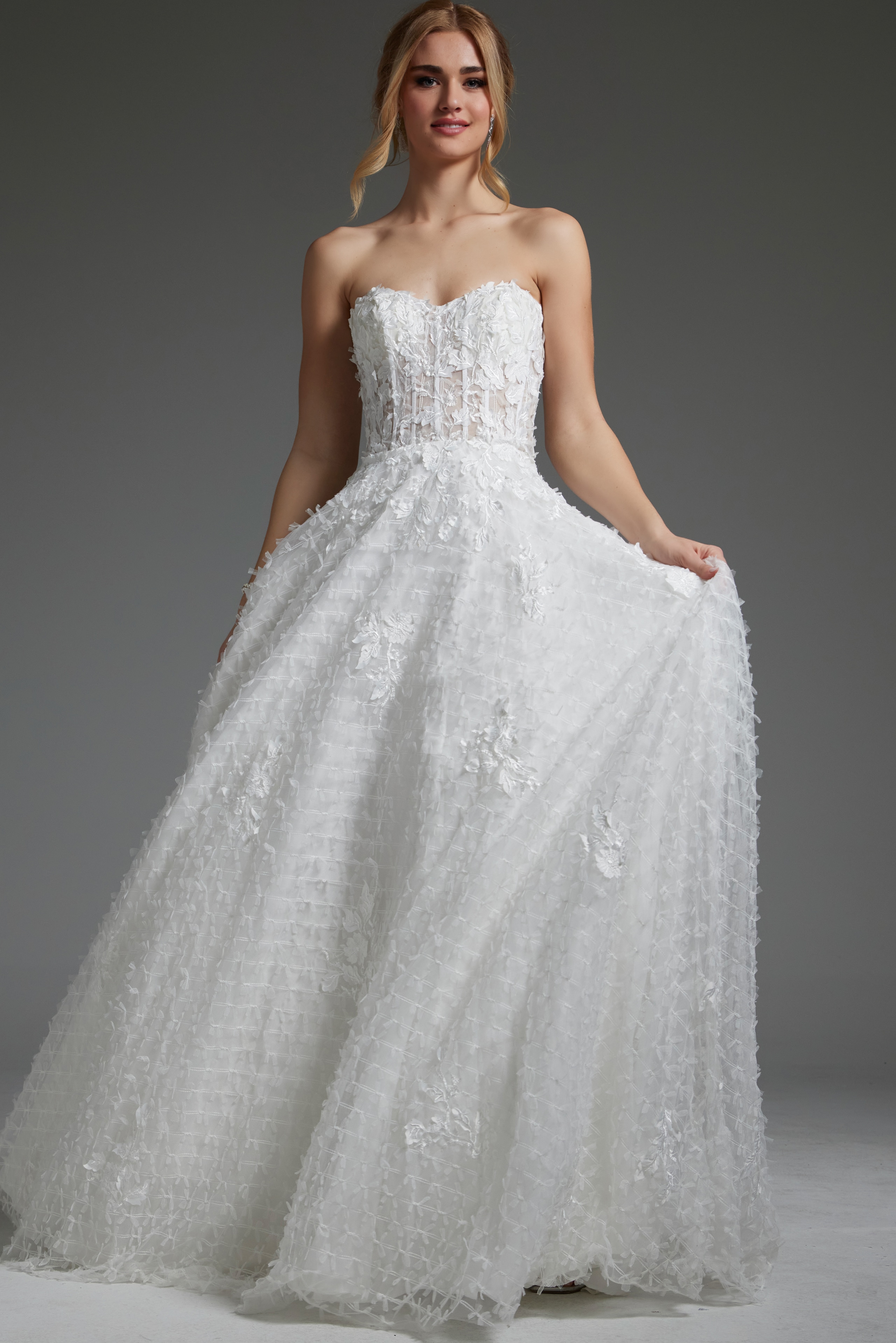 Model wearing Jovani JB07165 white gown with intricate floral patterns, front view.