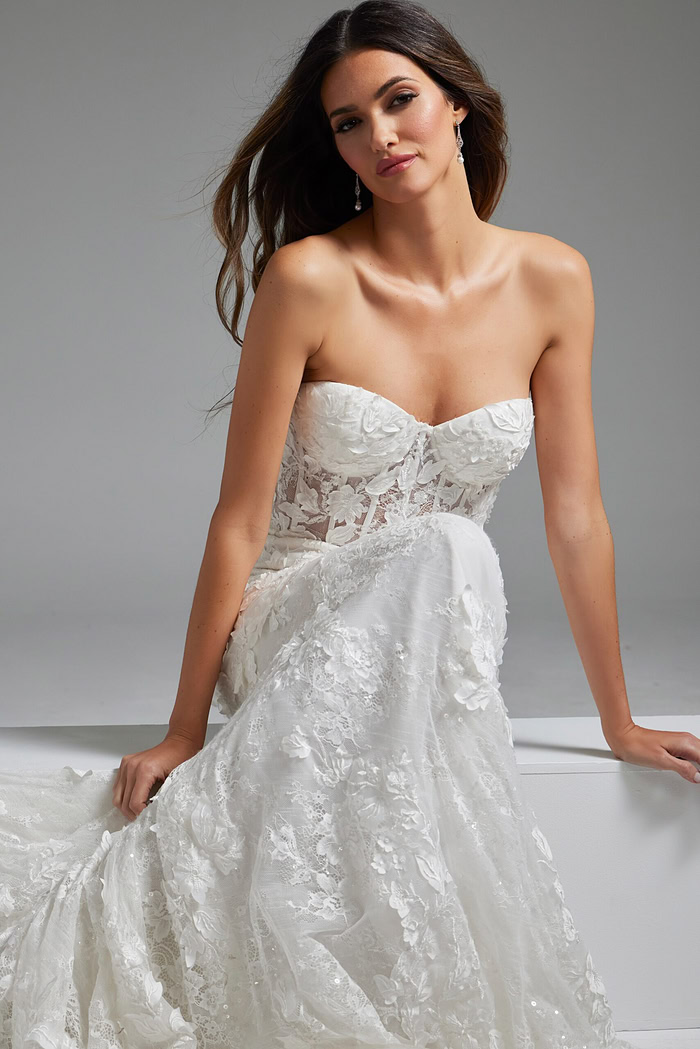 Model presents Jovani JB07583 white gown with elegant lace and strapless front.