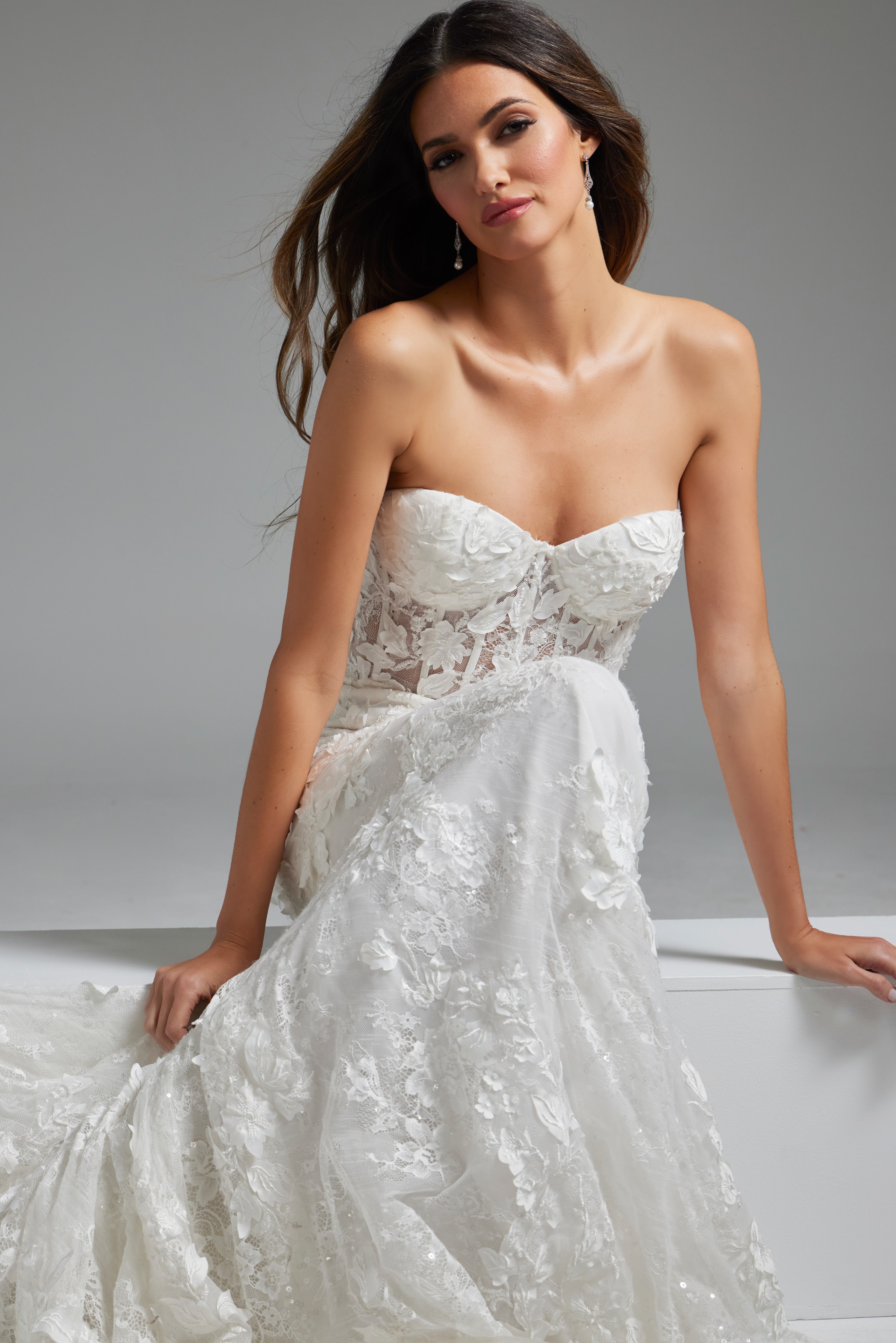 Model presents Jovani JB07583 white gown with elegant lace and strapless front.