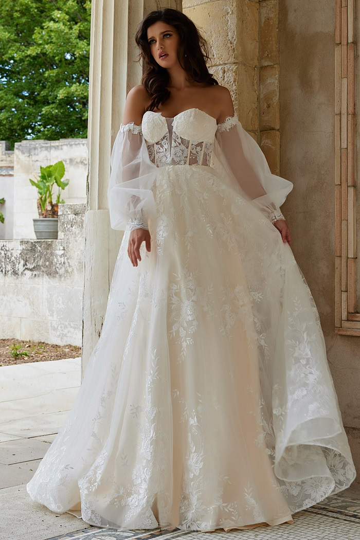 Model wearing Jovani JB220004 ivory dress with flowing skirt and lace details, front view.