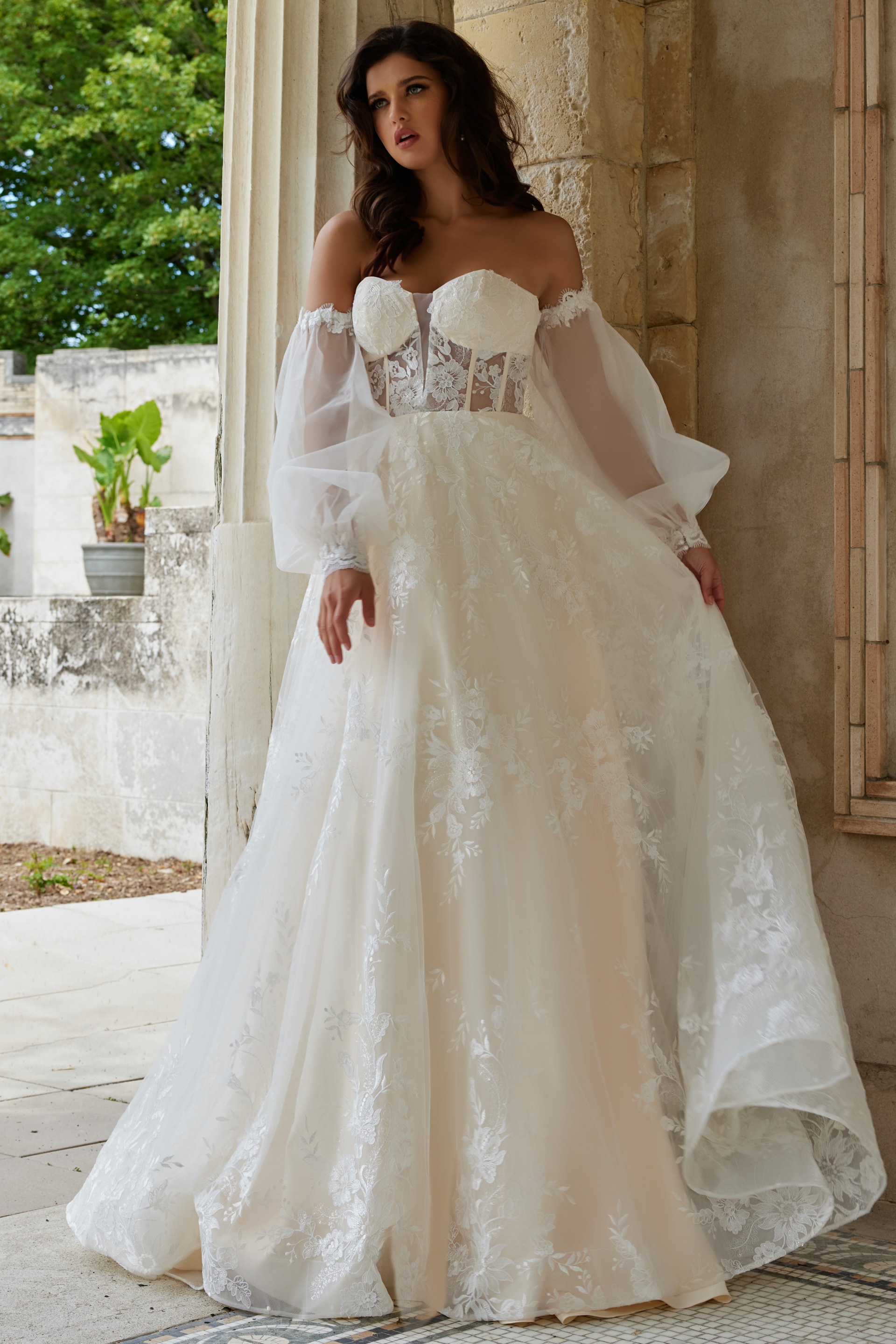 Model wearing Jovani JB220004 ivory dress with flowing skirt and lace details, front view.