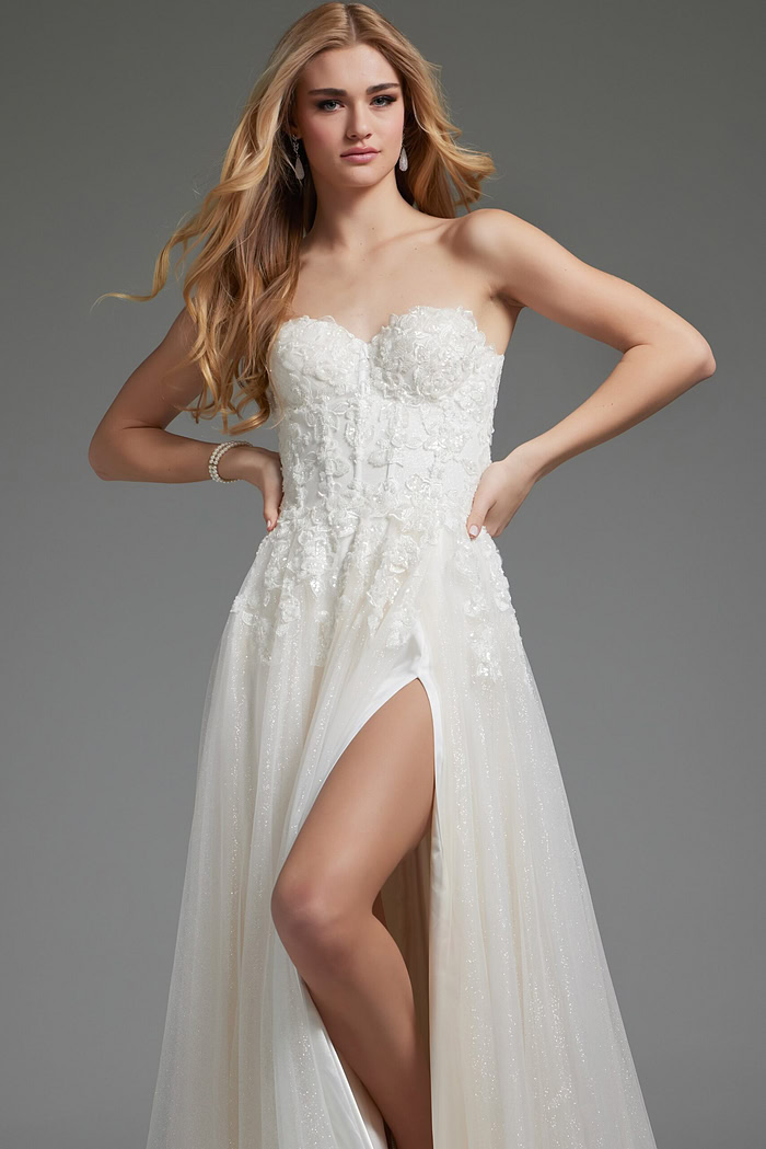 Model in white Jovani JB25730 gown with floral appliqués and high slit, front view.