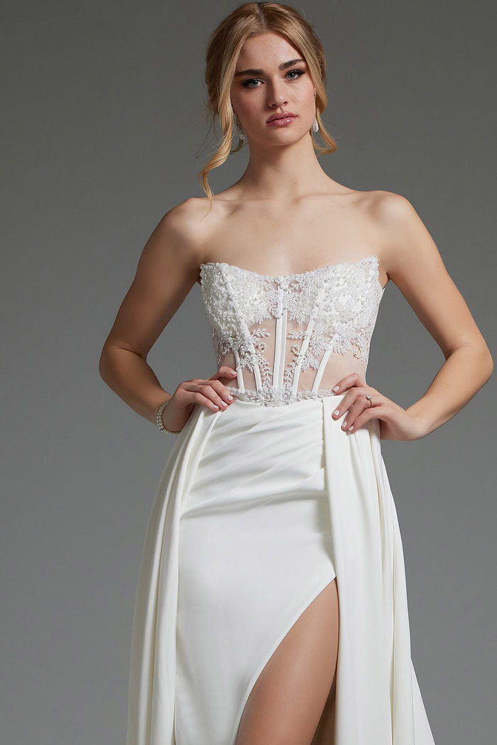 Model showcasing Jovani JB37128 ivory dress's lace bodice and high slit.