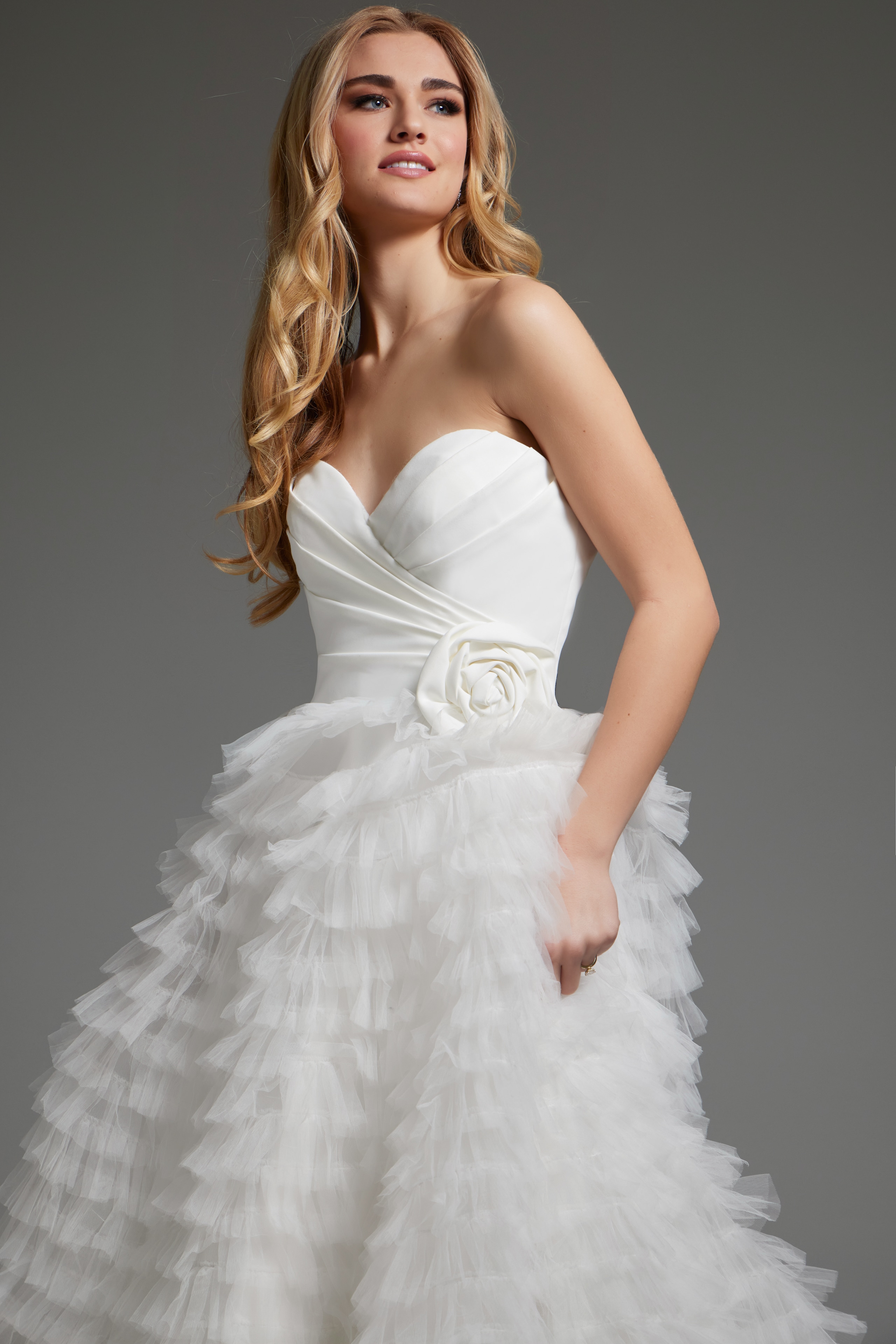 Model wearing Jovani JB38958 white gown with floral applique detail.