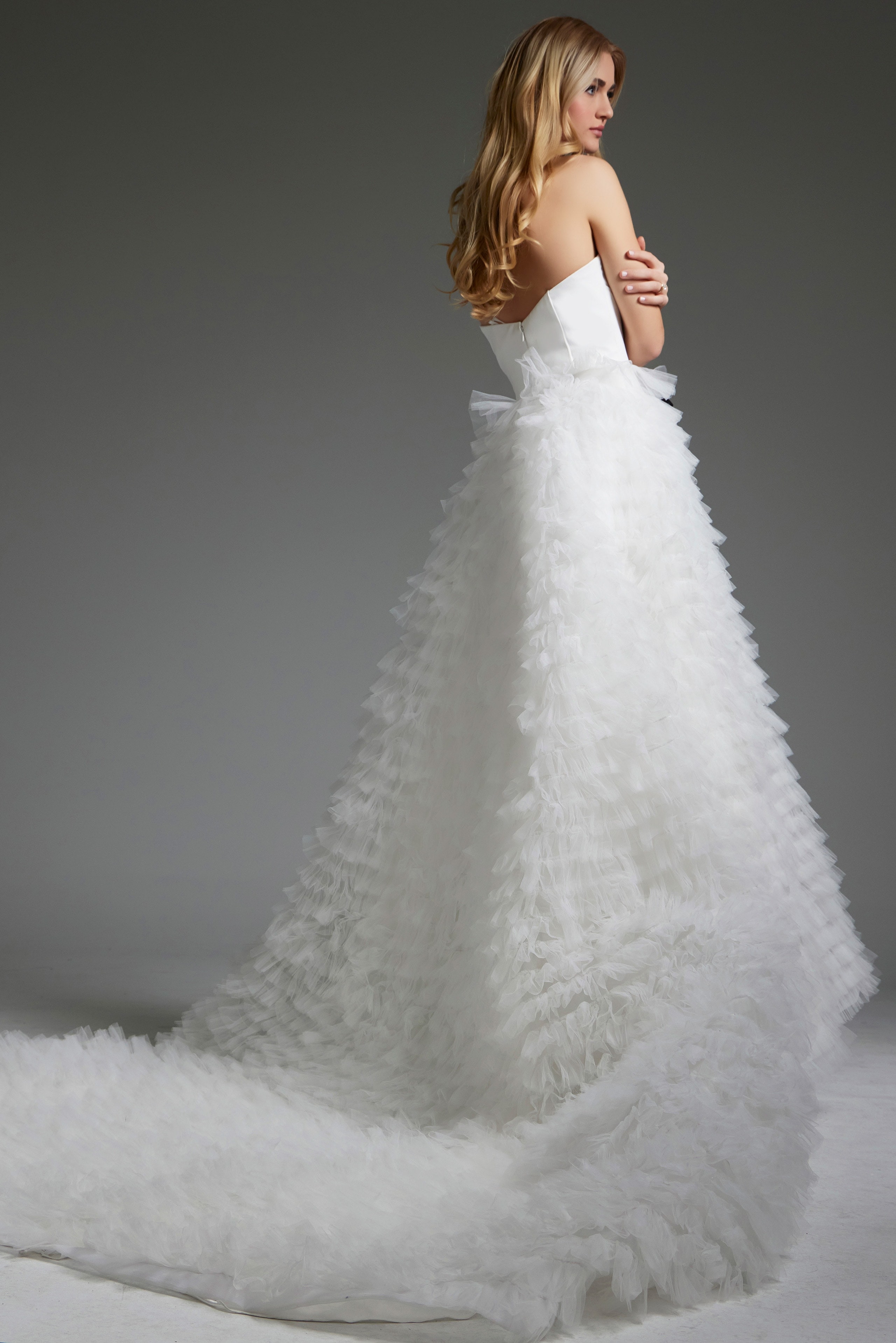 Side back view of model in Jovani JB38958 white gown featuring ruffles.