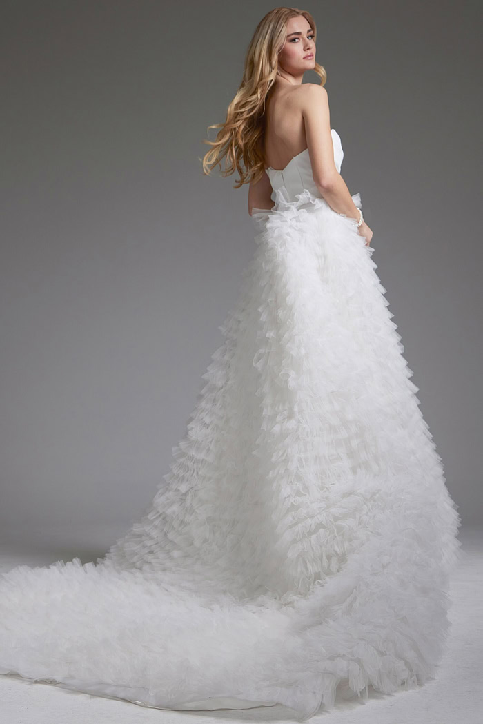 Back view of model wearing Jovani JB38958 white gown with ruffled skirt.