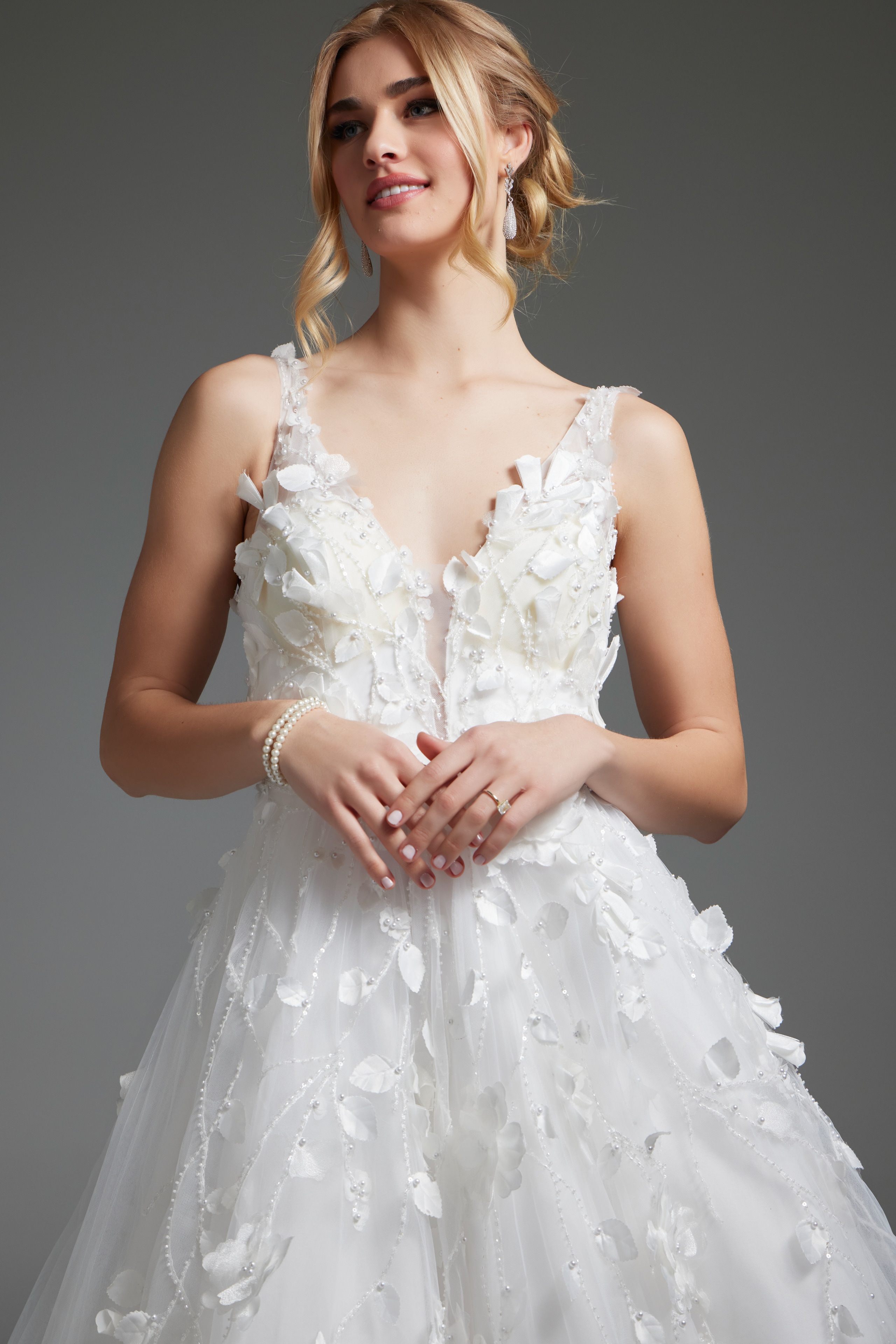 Model wearing Jovani JB40511 ivory gown, close-up front view, with deep V-neckline.