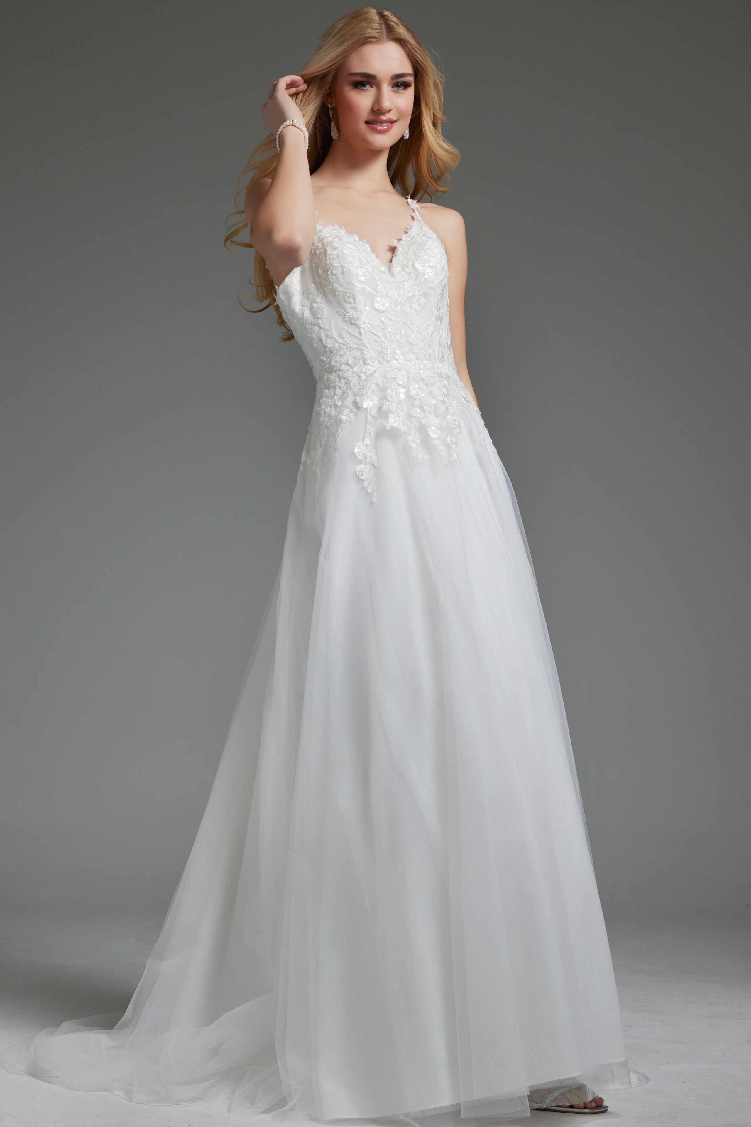 Model wearing Jovani jb40513 ivory gown with V-neckline and floral appliqués.