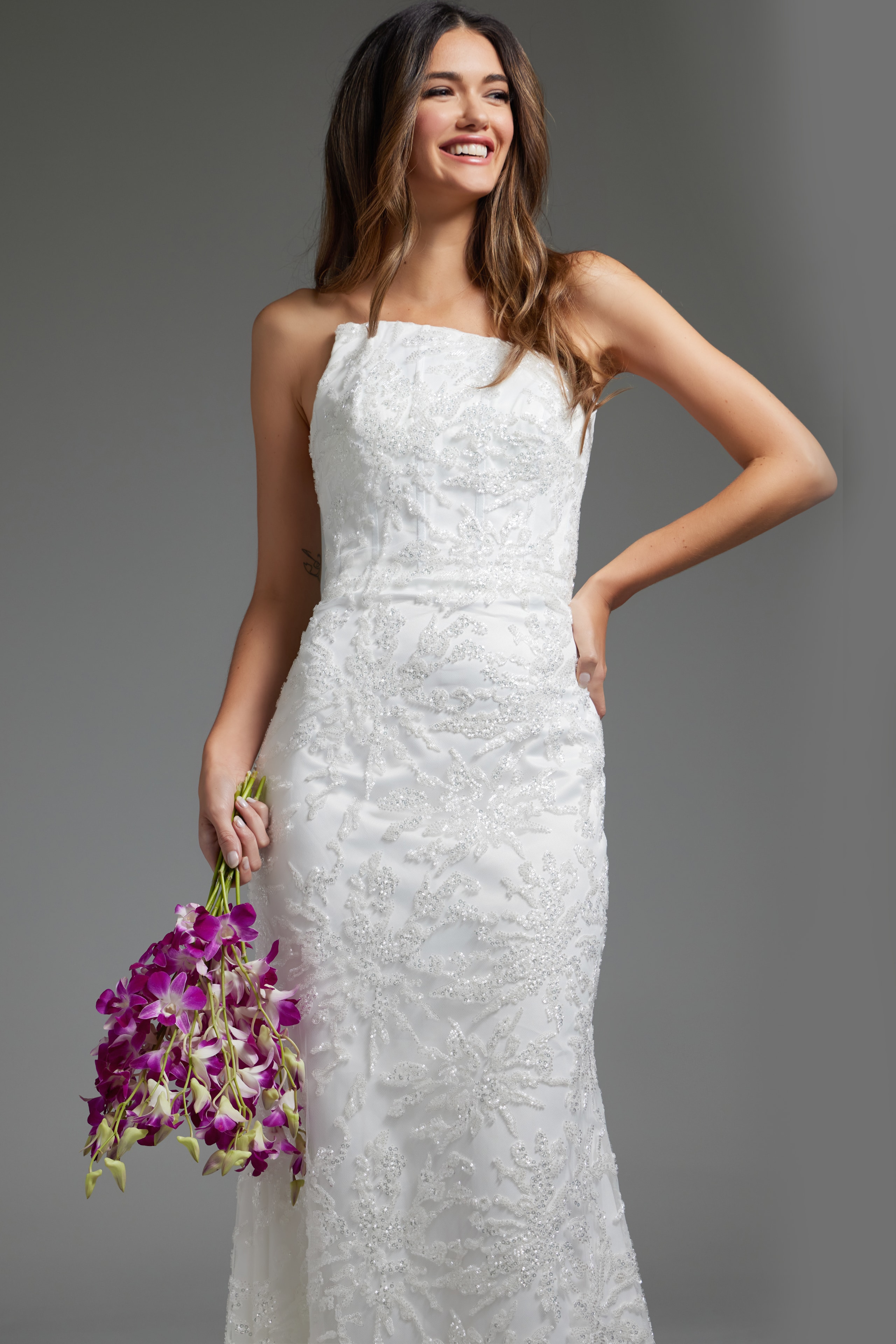 Model wearing JB40608 refined white gown holding flowers, showcasing the elegant lace design