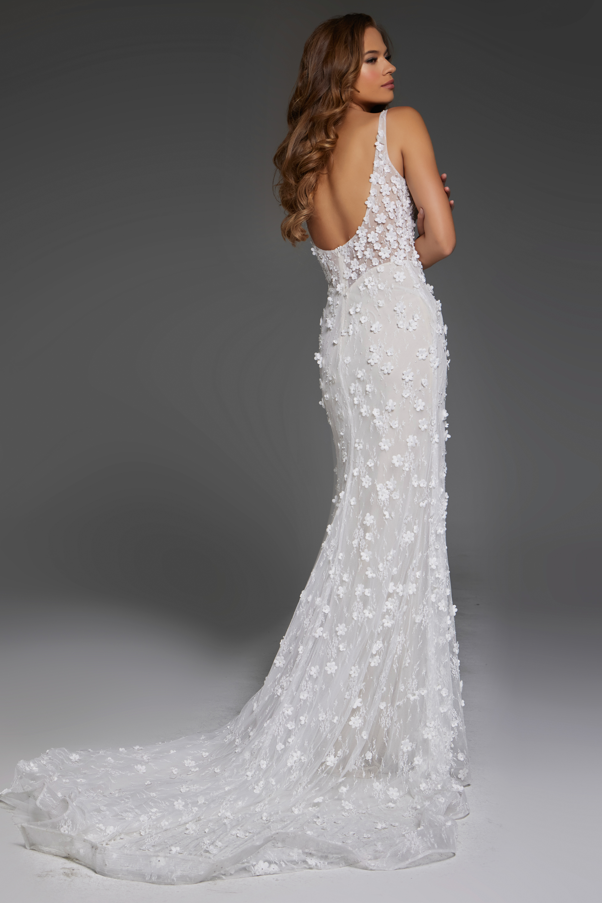 Model wearing Jovani JB42483 back view of white gown with plunging back and train.