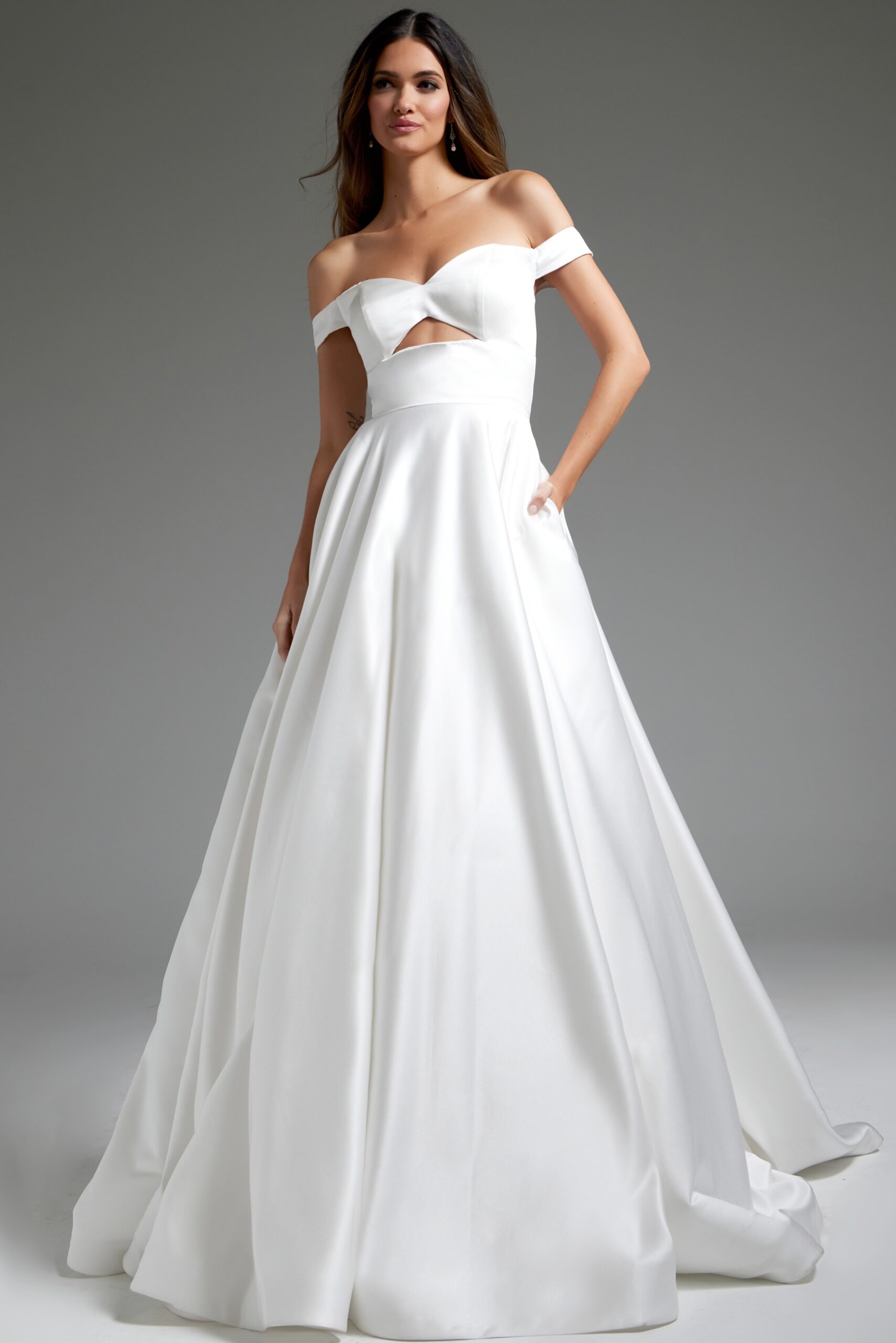 Model wearing Jovani JB42626 off-the-shoulder white dress with cutout at the bodice.