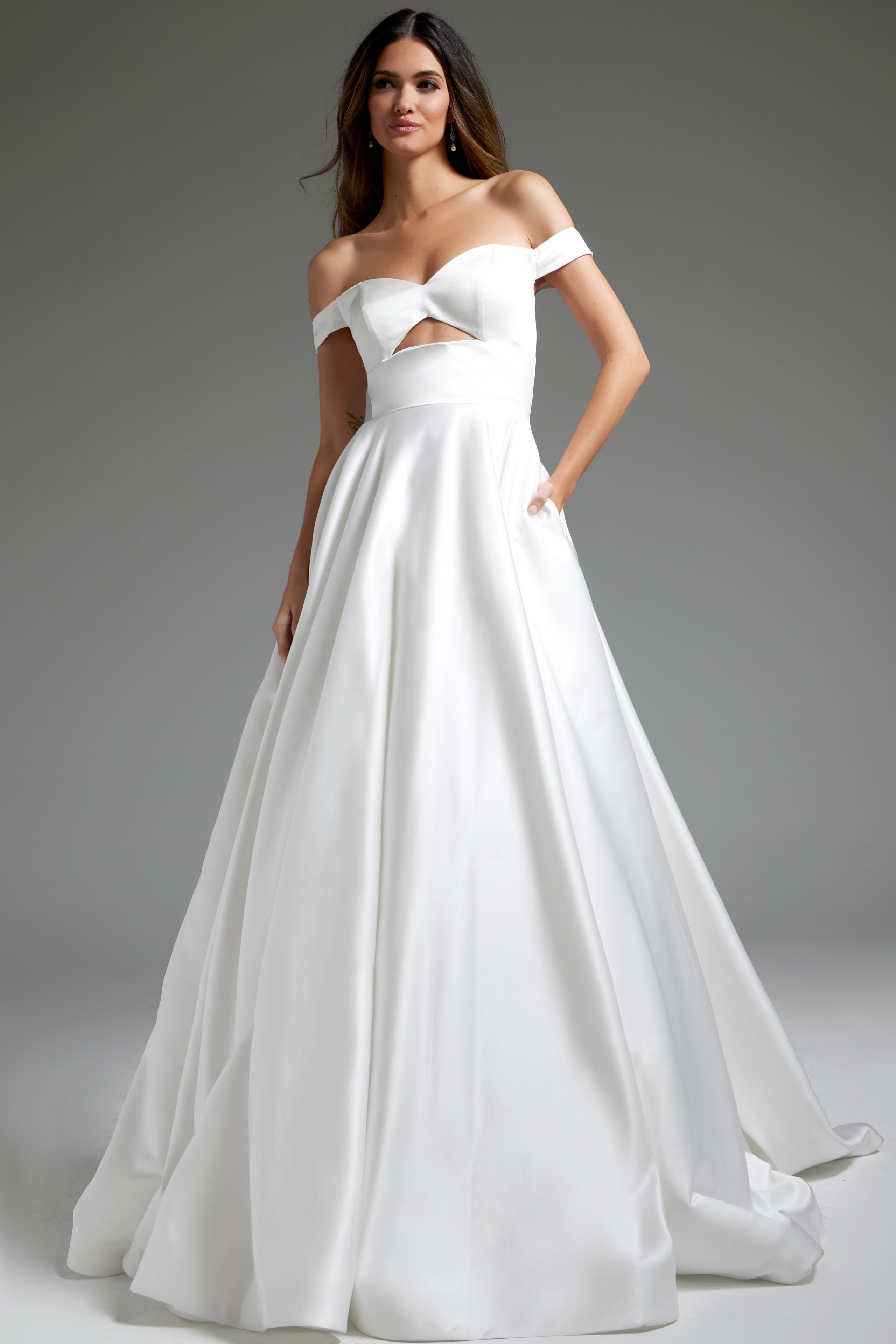 Model wearing Jovani JB42626 off-the-shoulder white dress with cutout at the bodice.