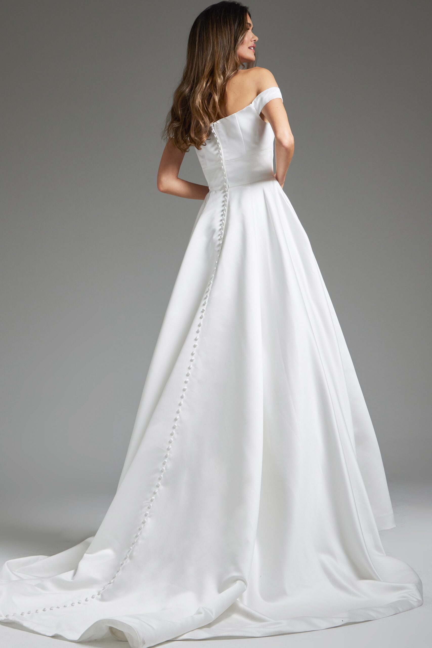 Back view of model in Jovani JB42626 showing the buttoned detail on white dress.