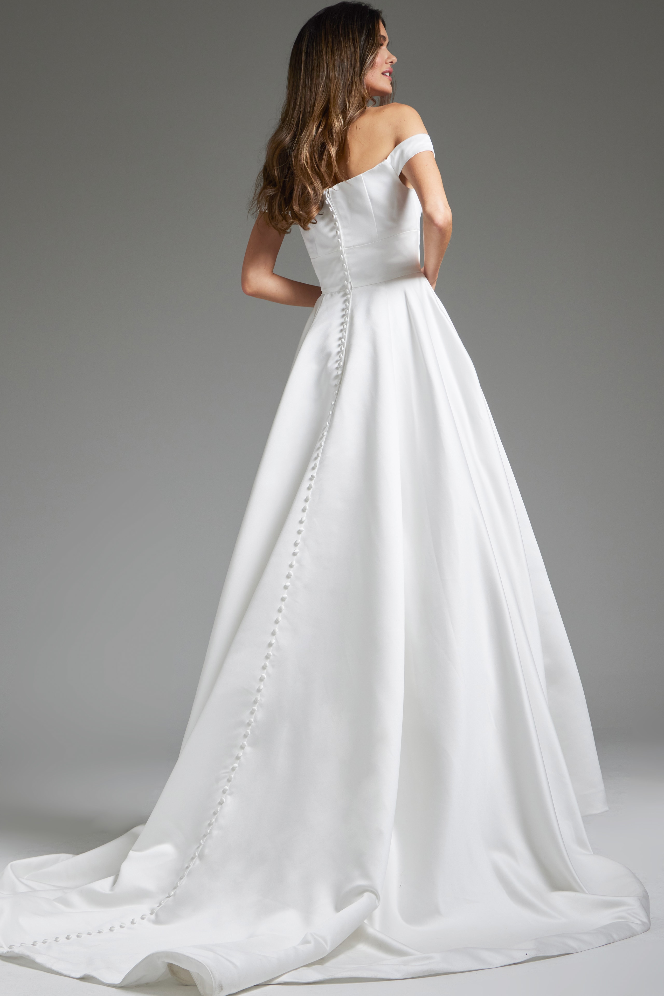 Back view of model in Jovani JB42626 showing the buttoned detail on white dress.