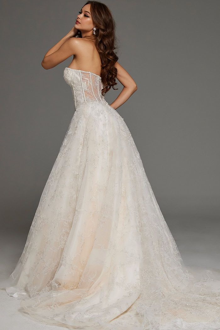 Back view of model in JB42766 white gown showcasing chapel train and lace detailing.