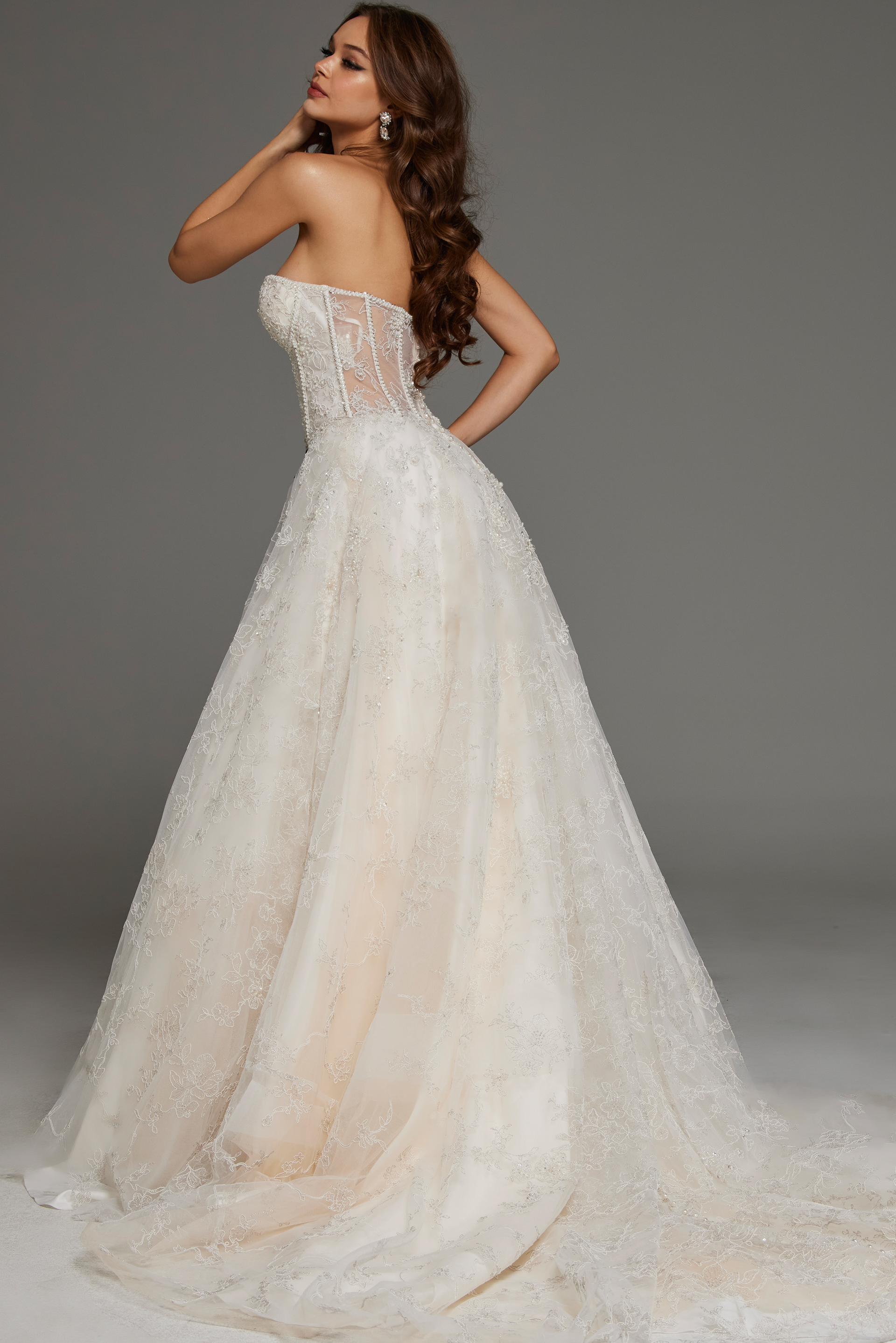 Back view of model in JB42766 white gown showcasing chapel train and lace detailing.