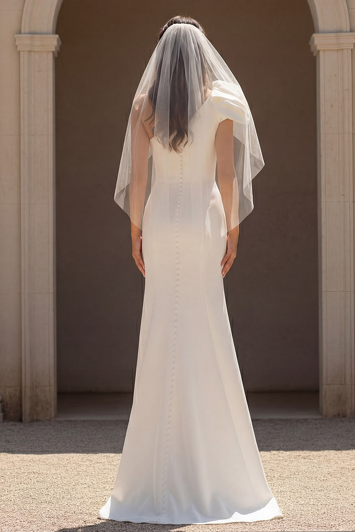Fitted bridal dress with buttoned back and sheer veil