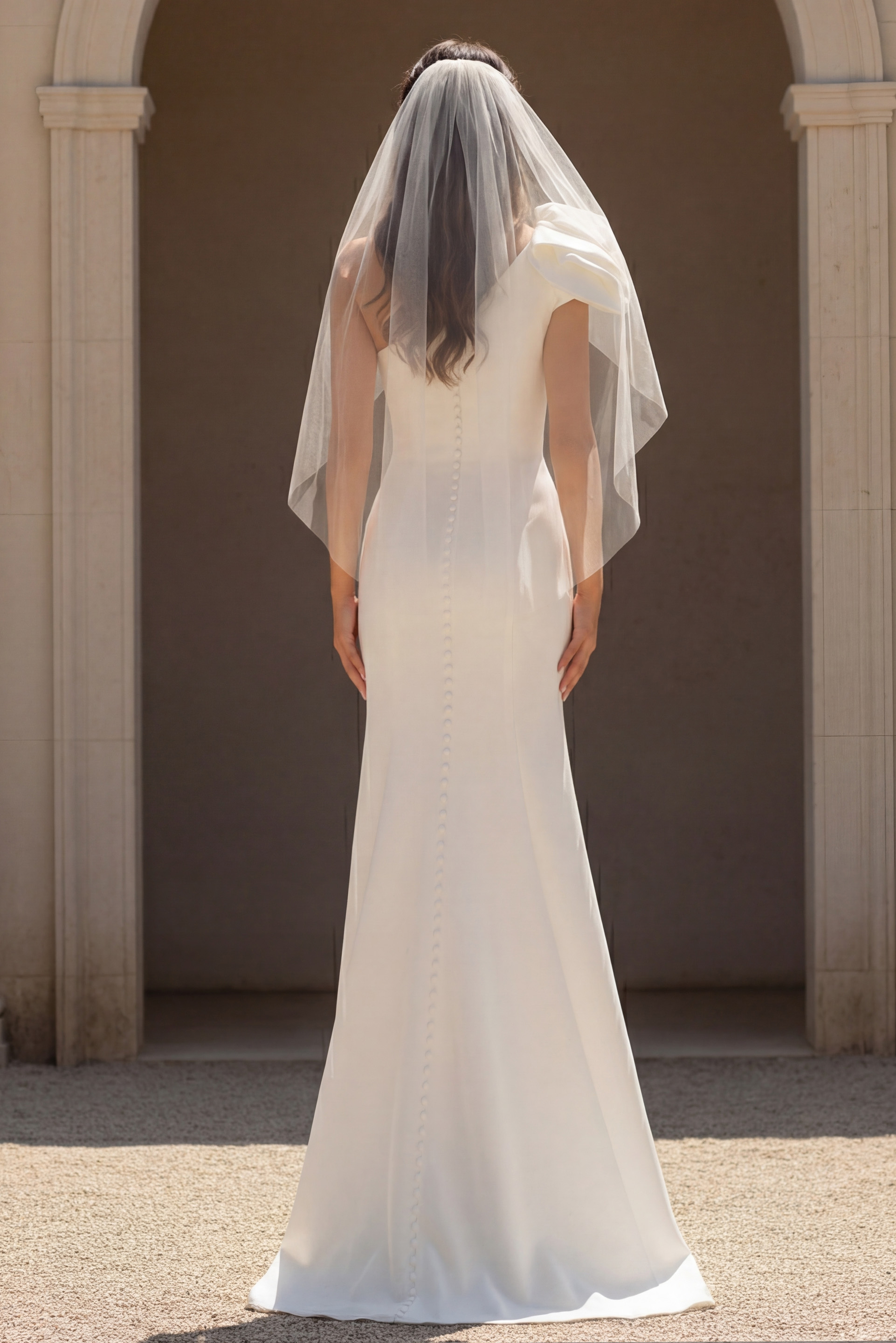 Fitted bridal dress with buttoned back and sheer veil
