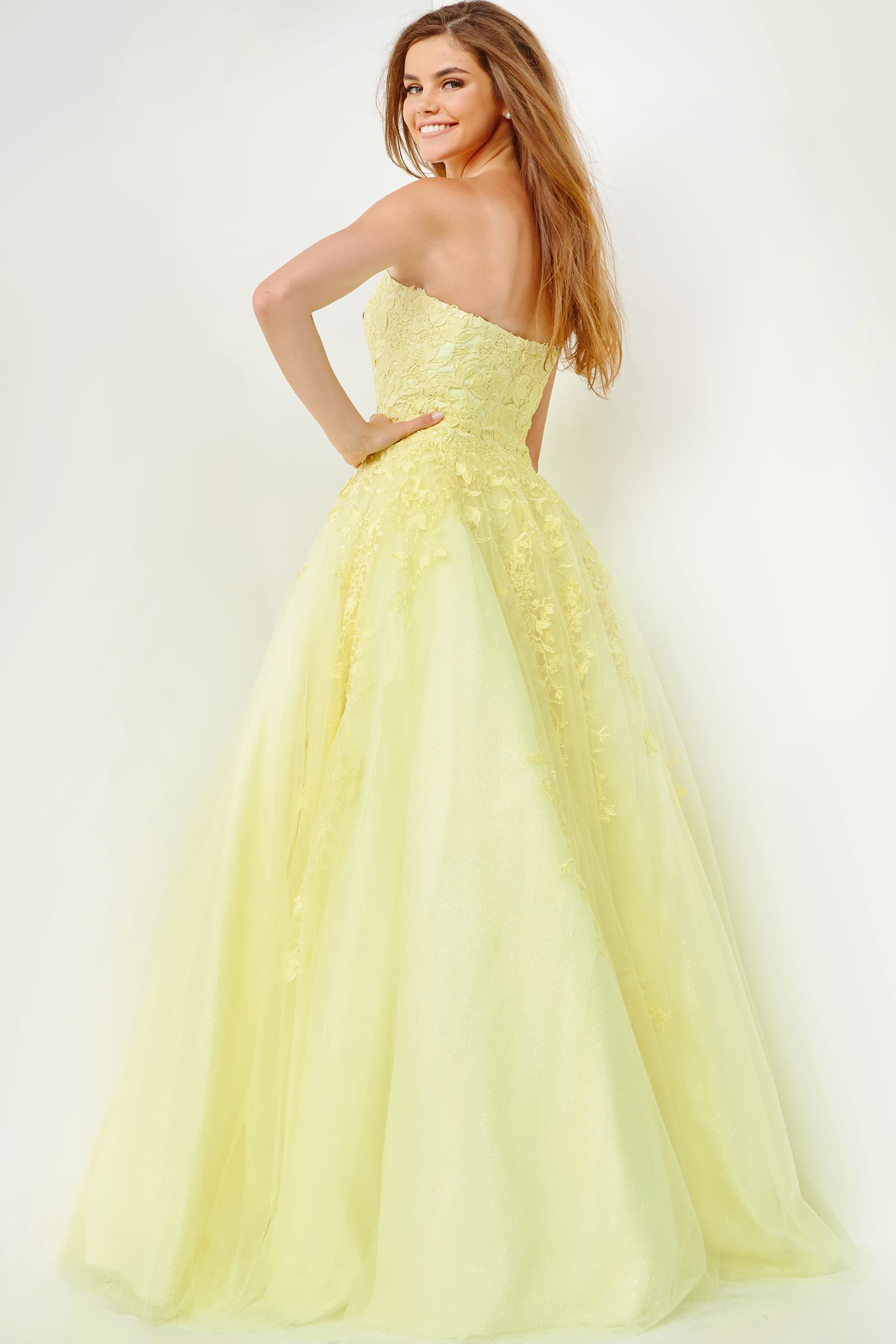 Model wearing Jovani 1831 ball gown in yellow, back view