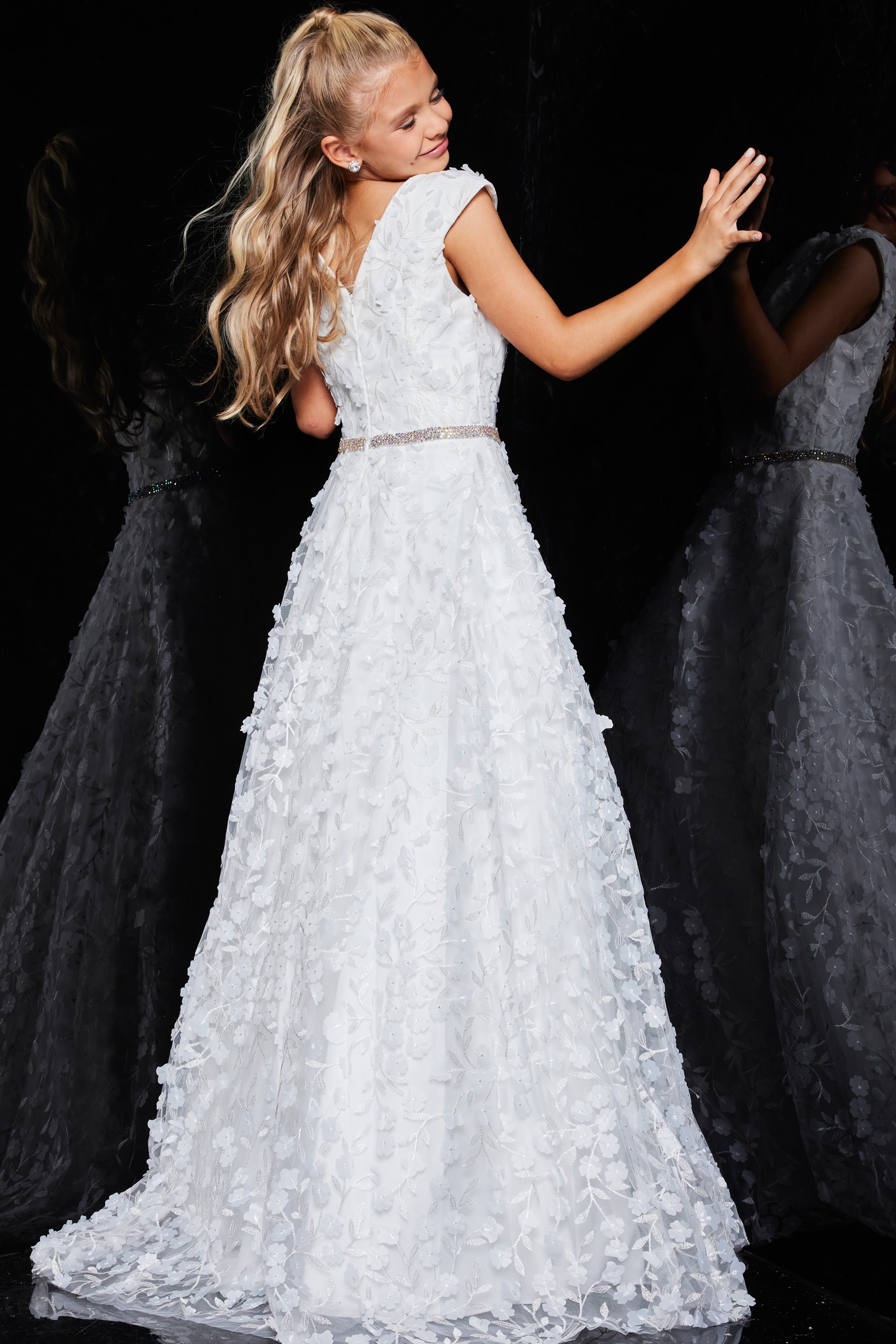 Back view of model in Jovani K07245 ivory gown with cap sleeves and floral appliqué.