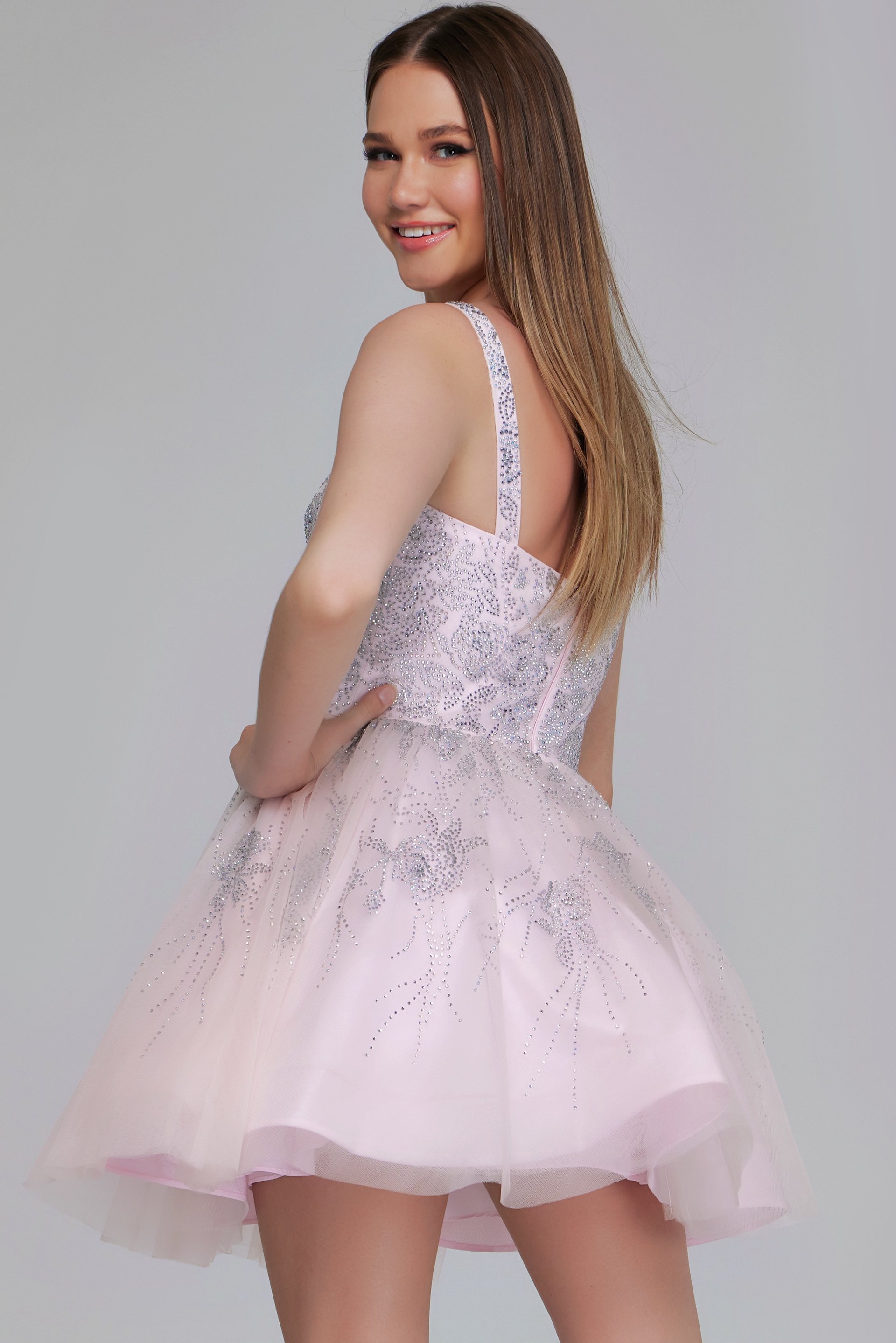 Model wearing K22943 pale pink dress, back view with sequin details.